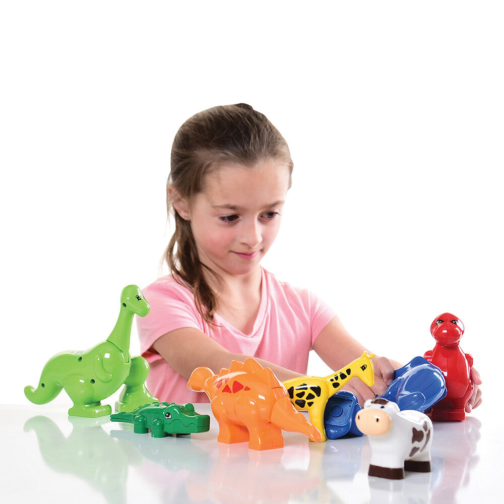 Kid in pink shirt playing with preschool block animals on white background