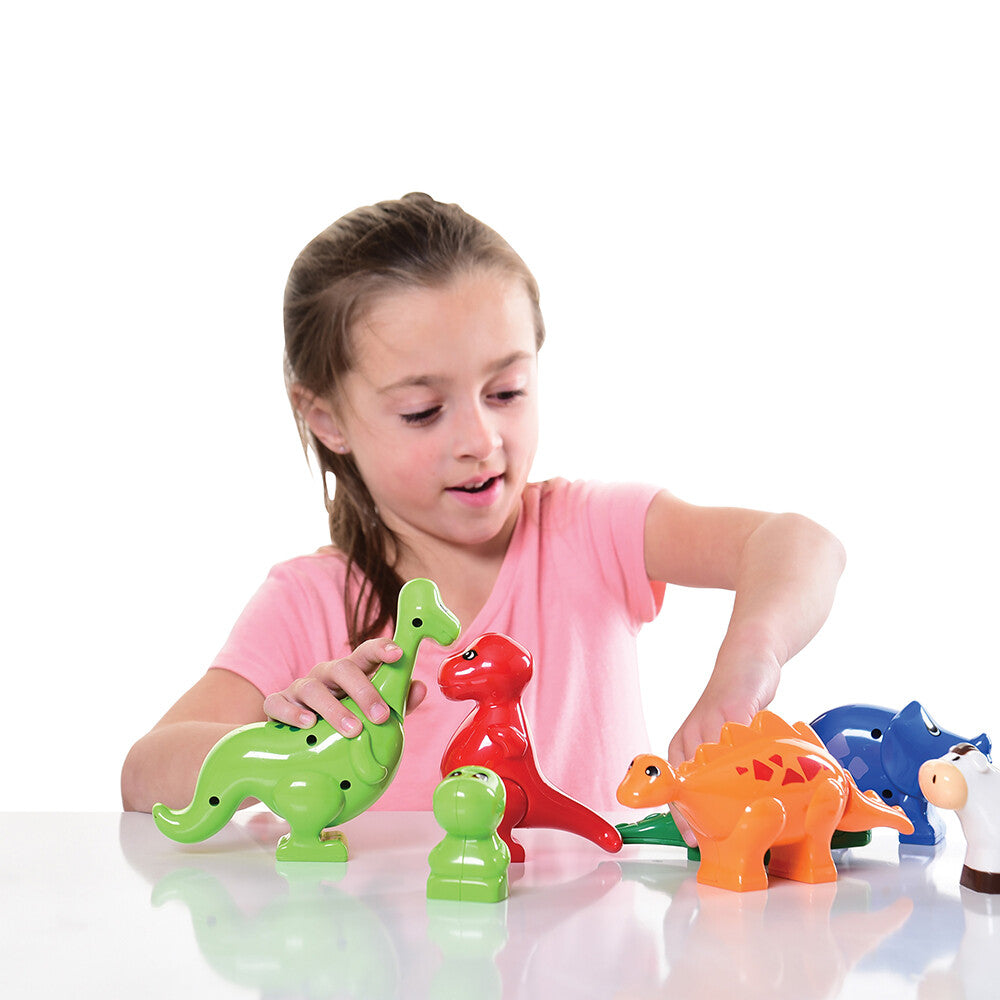 Kid in pink shirt playing with preschool block animals on white background