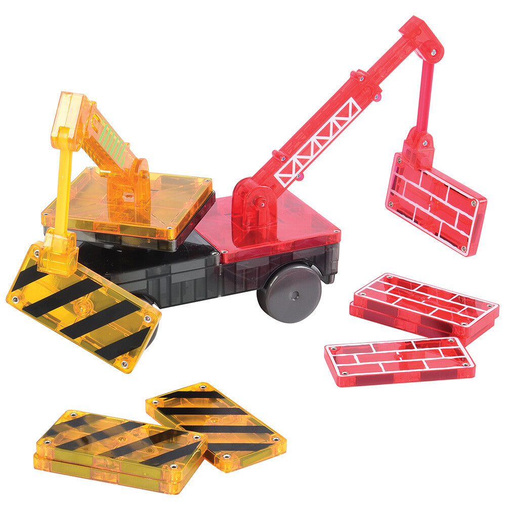 A collection of colorful Magna-Tiles set up to build a construction theme scene with magnetic cranes and road signs.