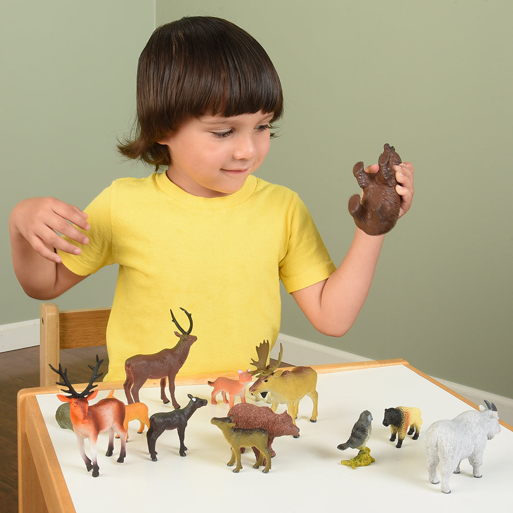 Child Exploring Pretend Play with Forest Animals Figures