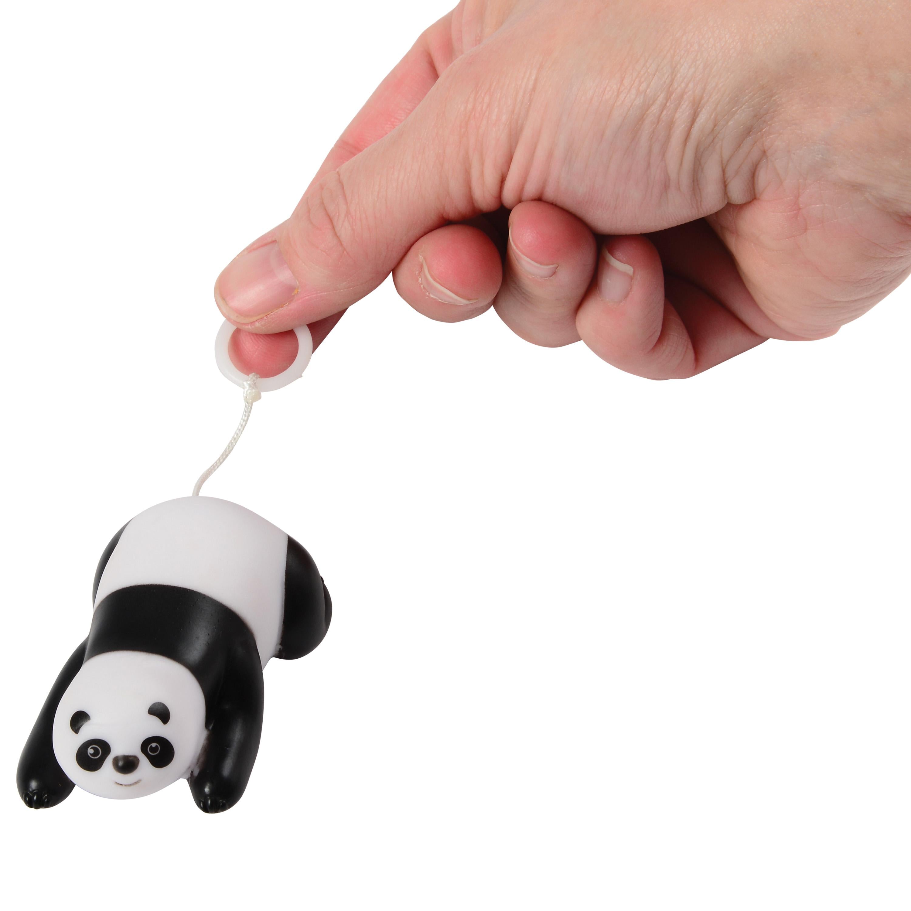 Panda-shaped action toy held by a hand on a white background