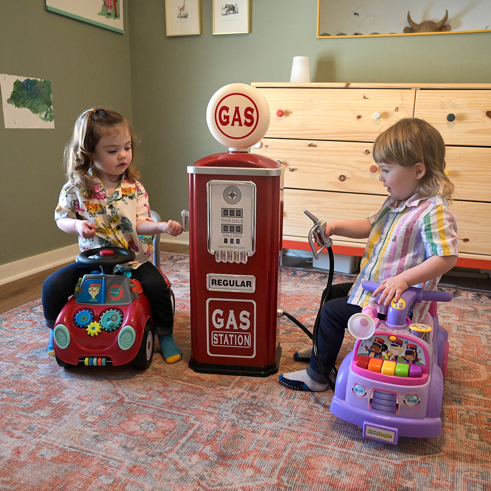 Two Toddlers using Steel Gas Pump Replica