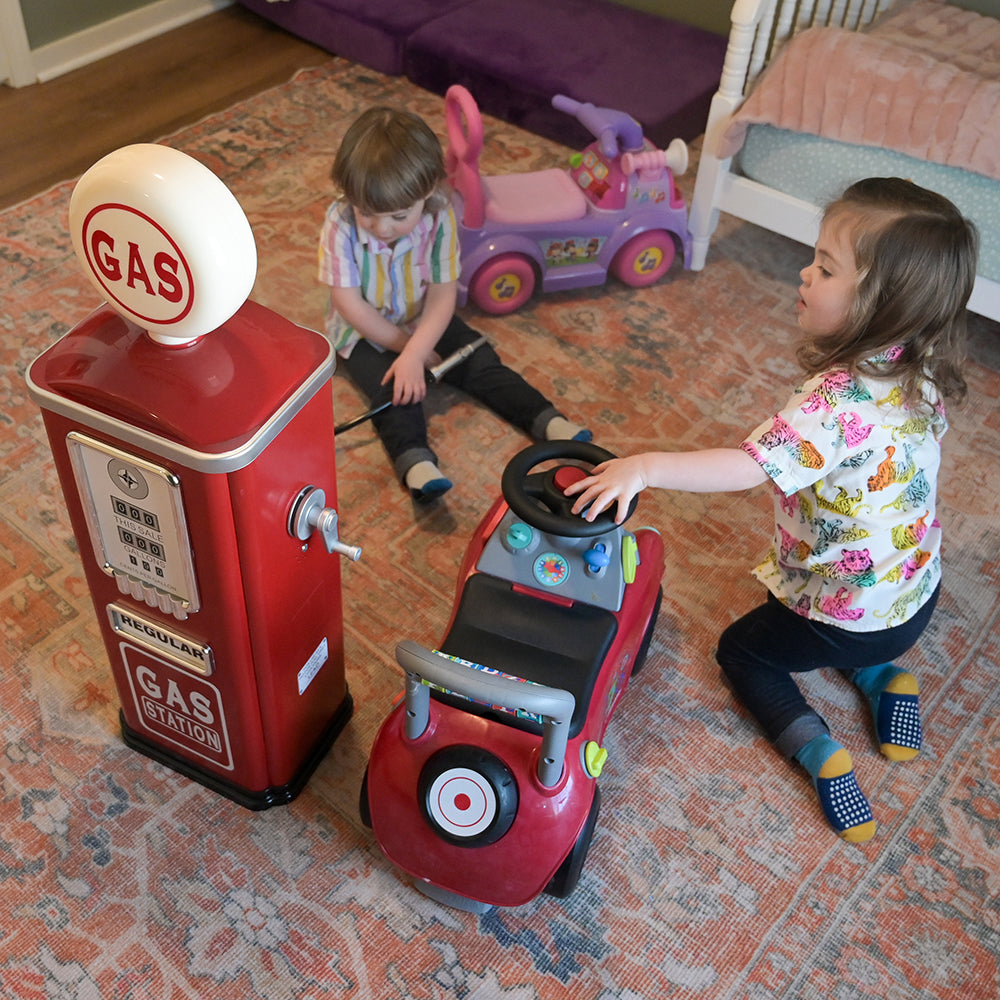 Toddlers Engaging with Steel Gas Pump Replica