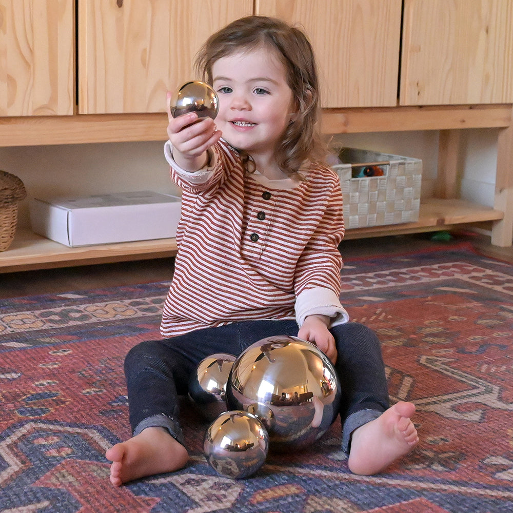 Toddler Showing Difference in Size with Sensory Reflective Mirror Balls