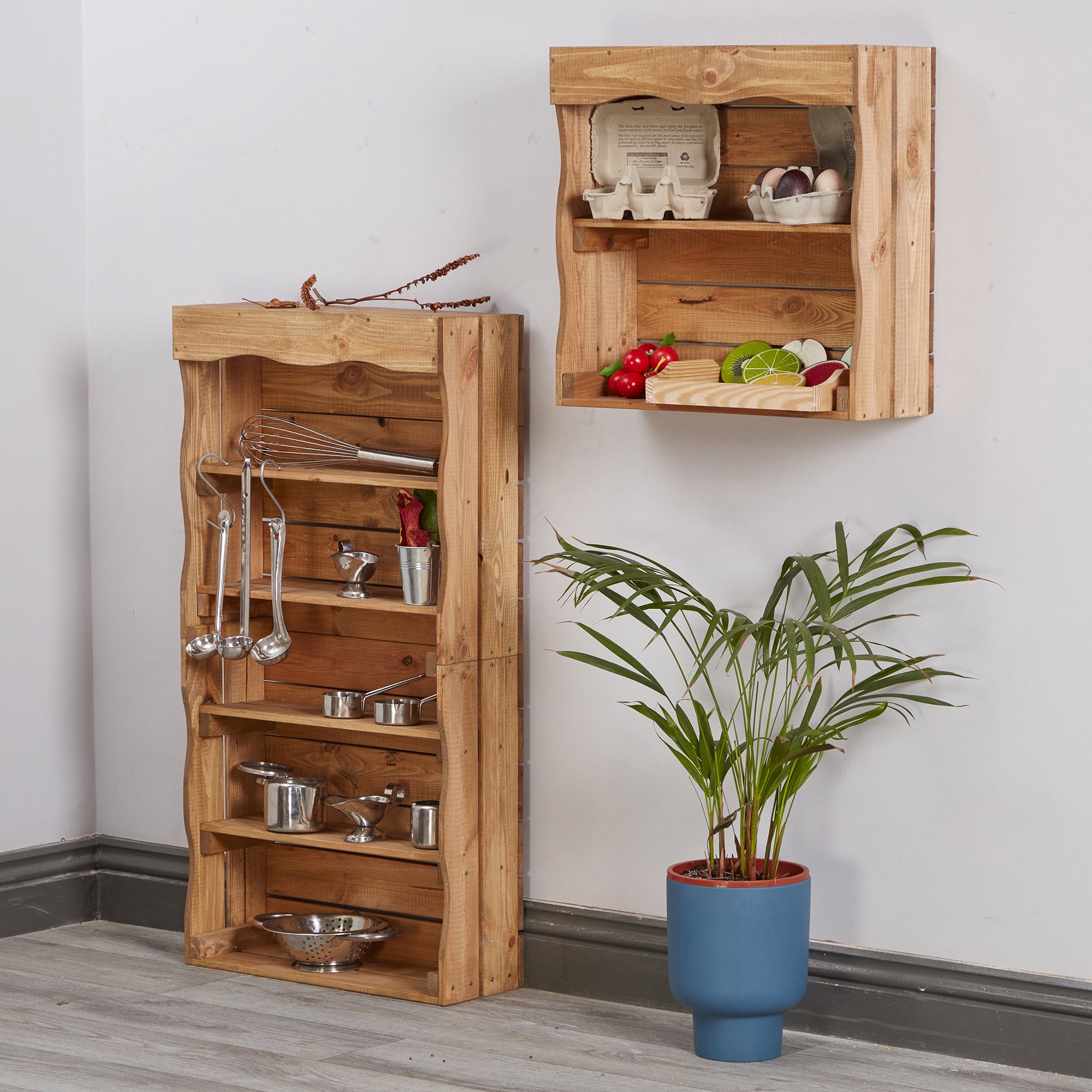 Wooden kitchen shelves with utensils and a plant on a light gray floor.