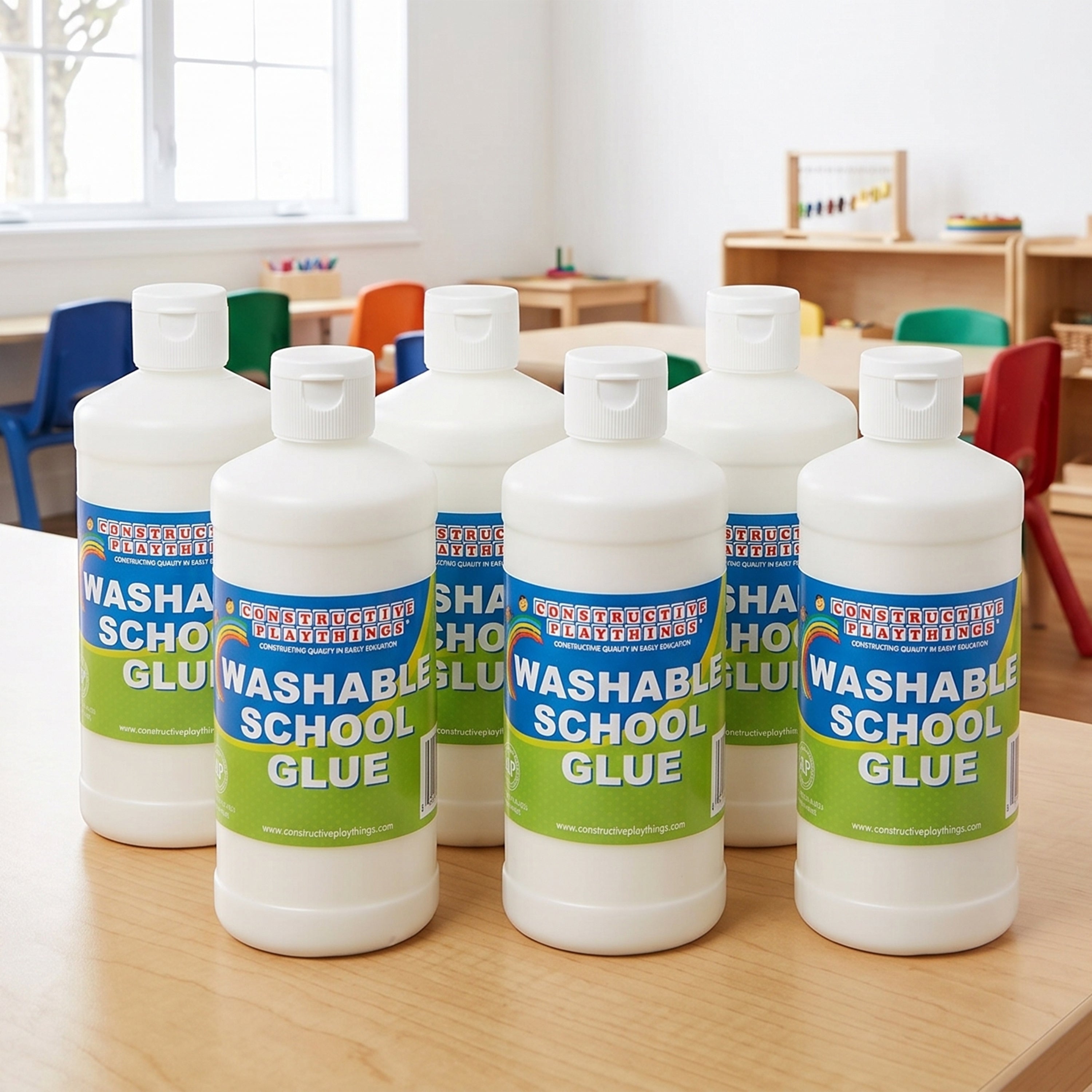 Bottles of washable school glue on a table in a classroom setting