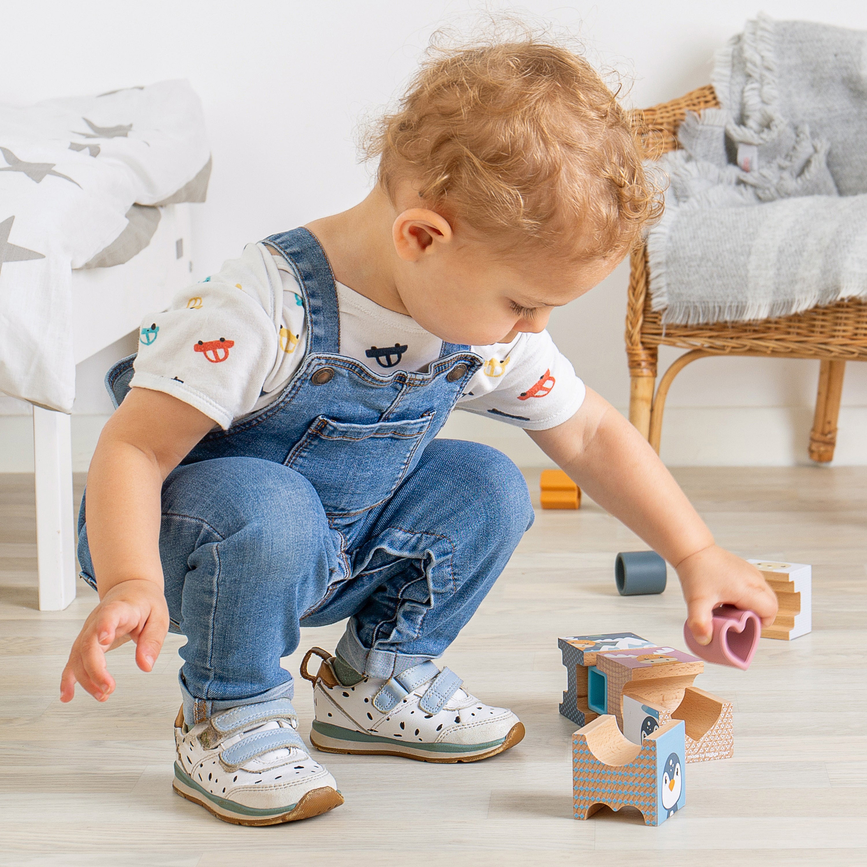Child playing with toys on a wooden floor in a home setting