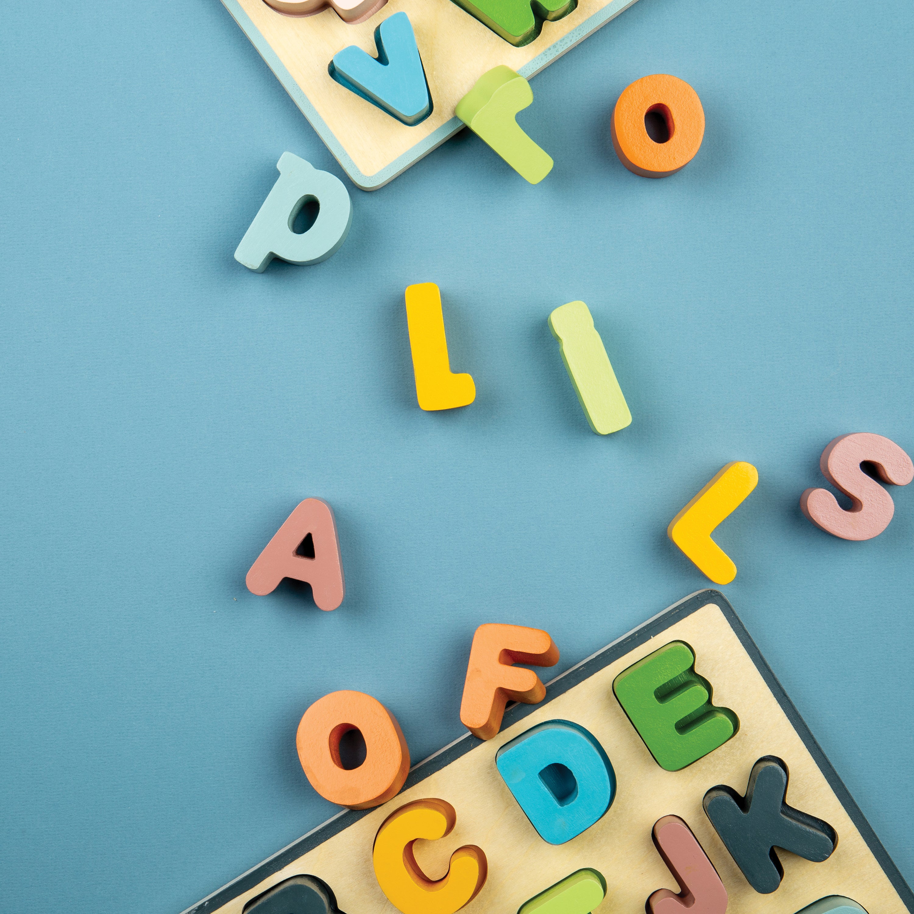 Colorful wooden letters scattered on a blue background with letter puzzles.