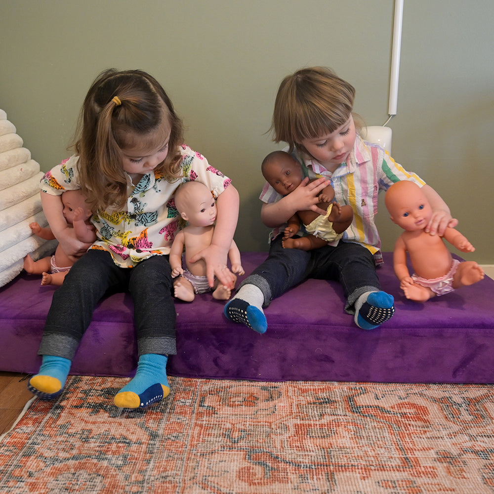 Toddlers Engaging with Multi-Ethnic Tender-Touch Baby Dolls