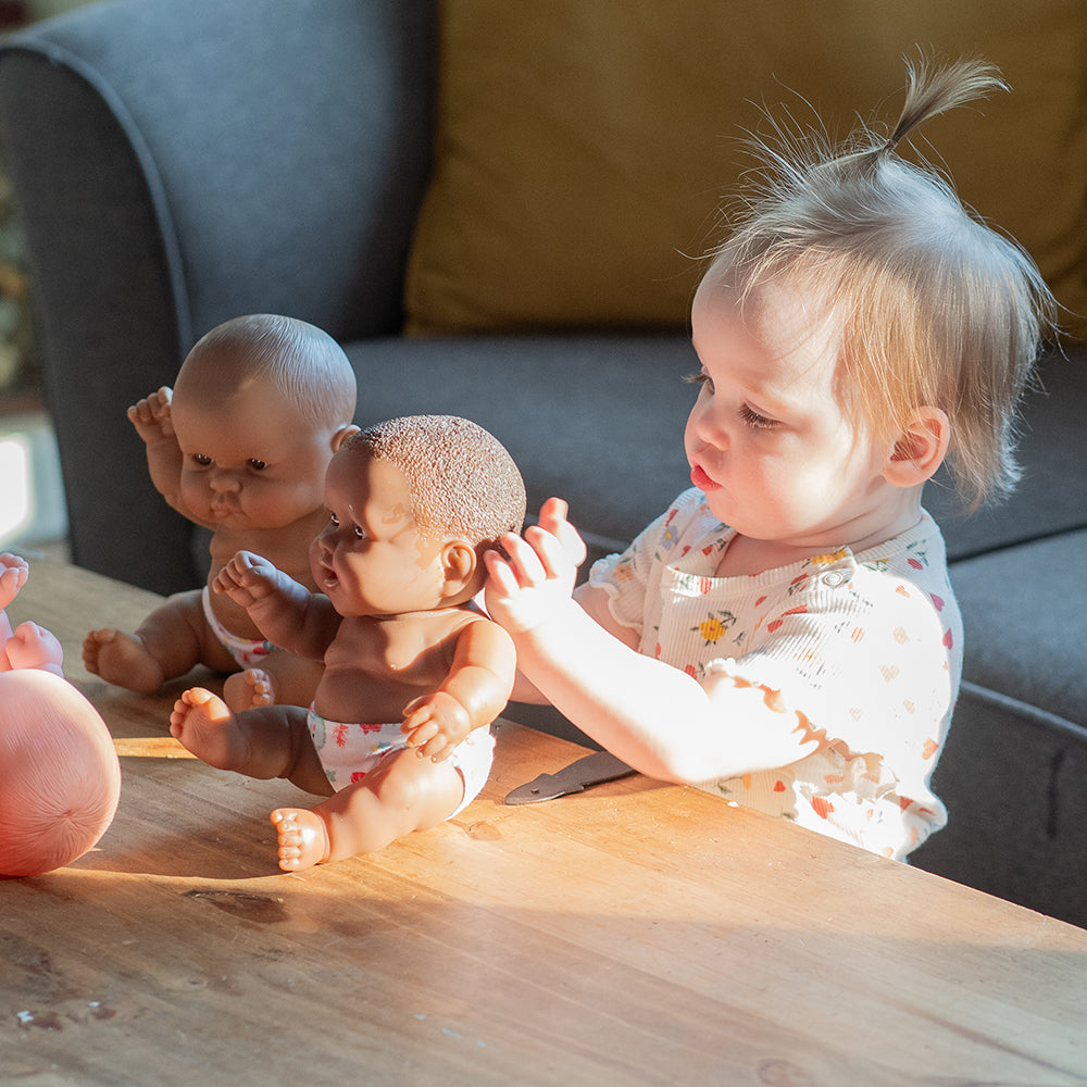 Toddler Interacting with Baby Dolls