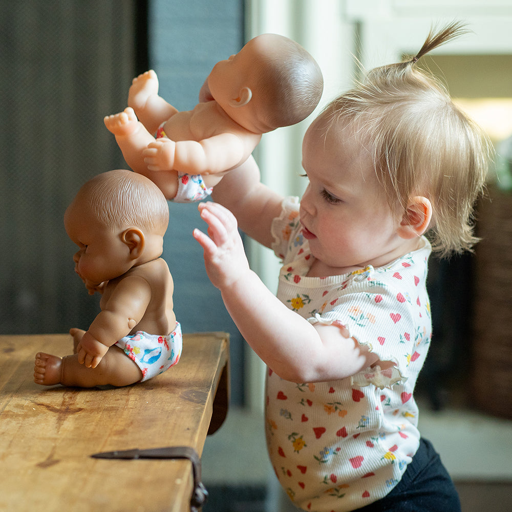 Toddler Interacting with Baby Dolls