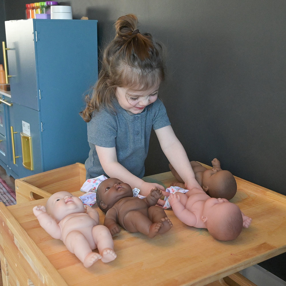 Toddler Practicing Dressing Baby Dolls