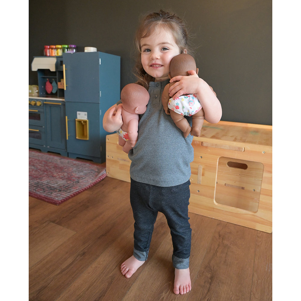 Toddler Hugging Diverse Baby Dolls