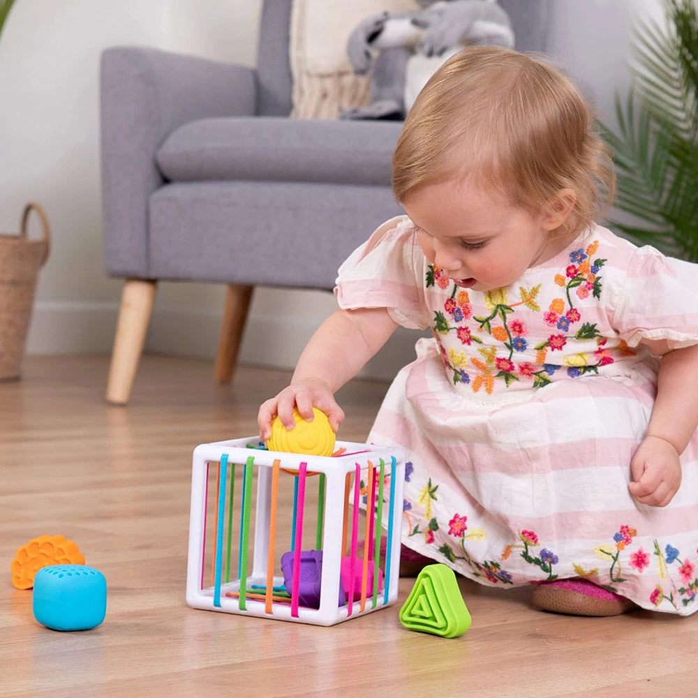 Toddler Engaging with Sensory Shape-Sorting Cube