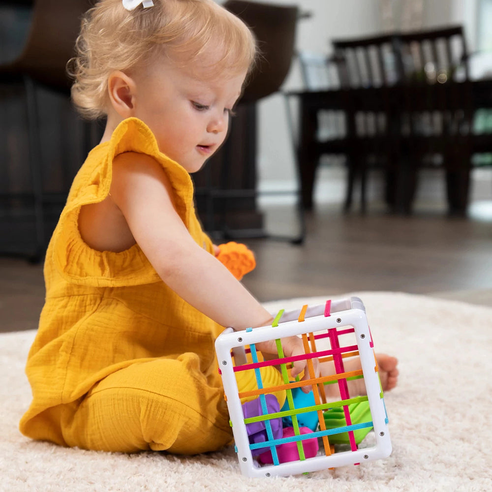 Toddler With Hand Inside Sensory Shape-Sorting Cube