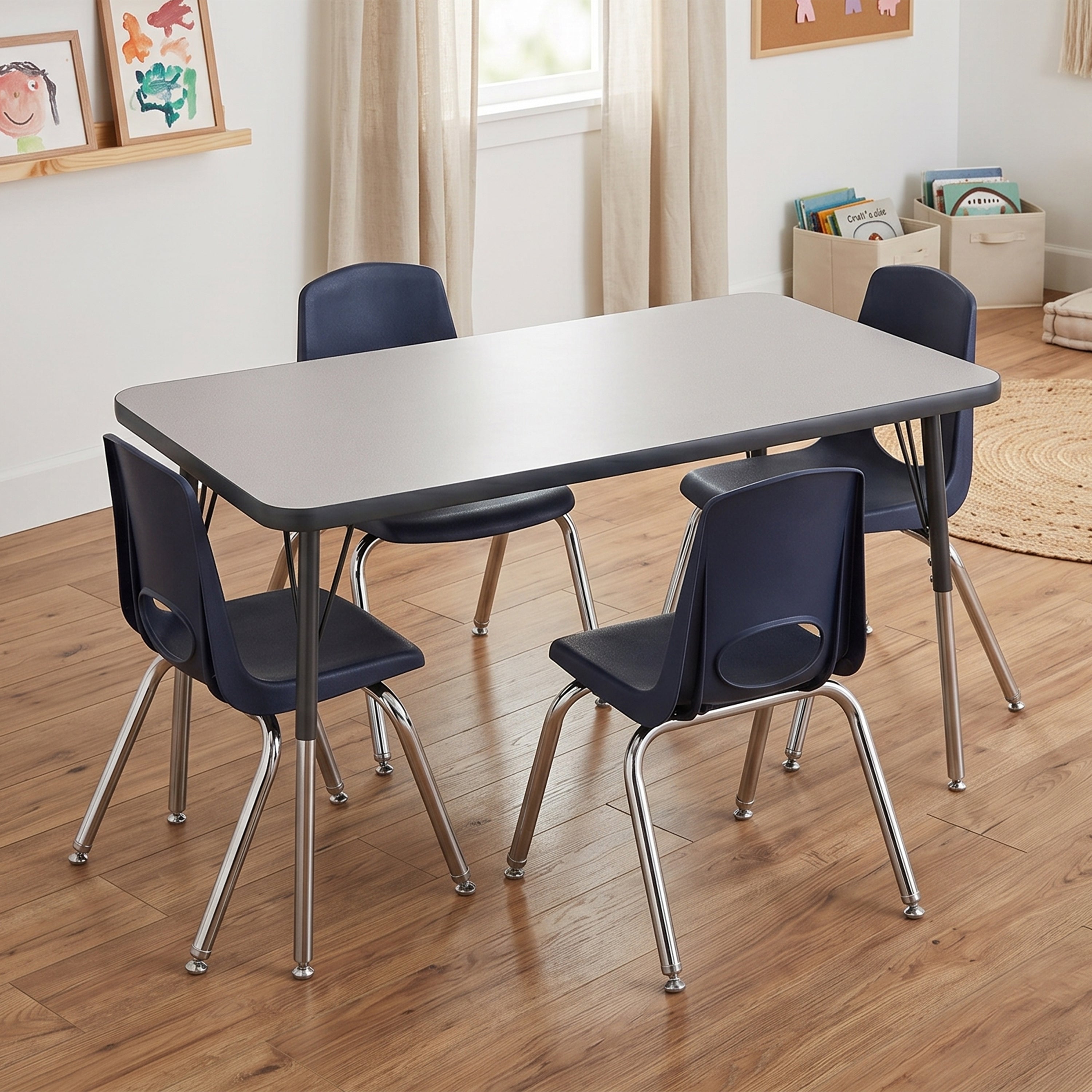 A children's table and chair set in a bright classroom setting. The set includes a rectangular table with a gray top and dark gray frame, surrounded by four chairs with dark blue seats and chrome legs.