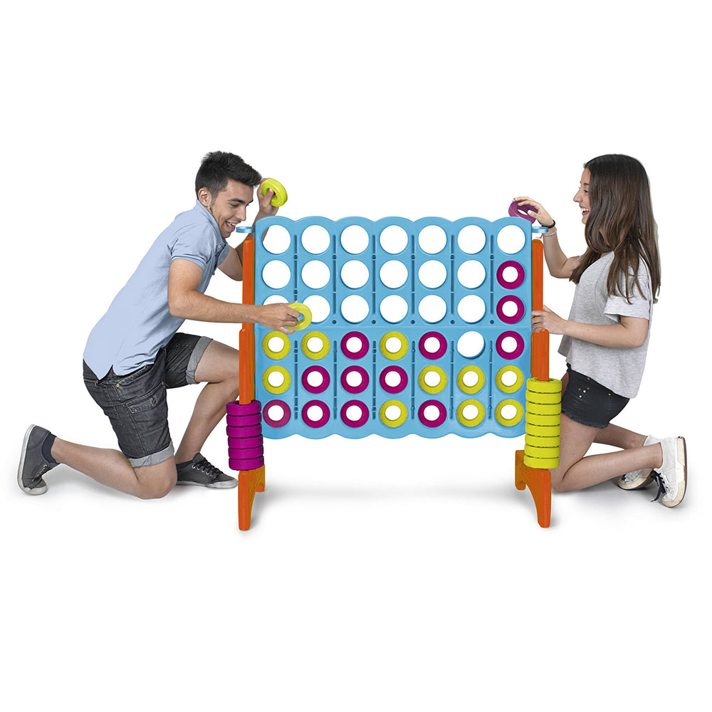 Two people playing with a large connect four game on a white background