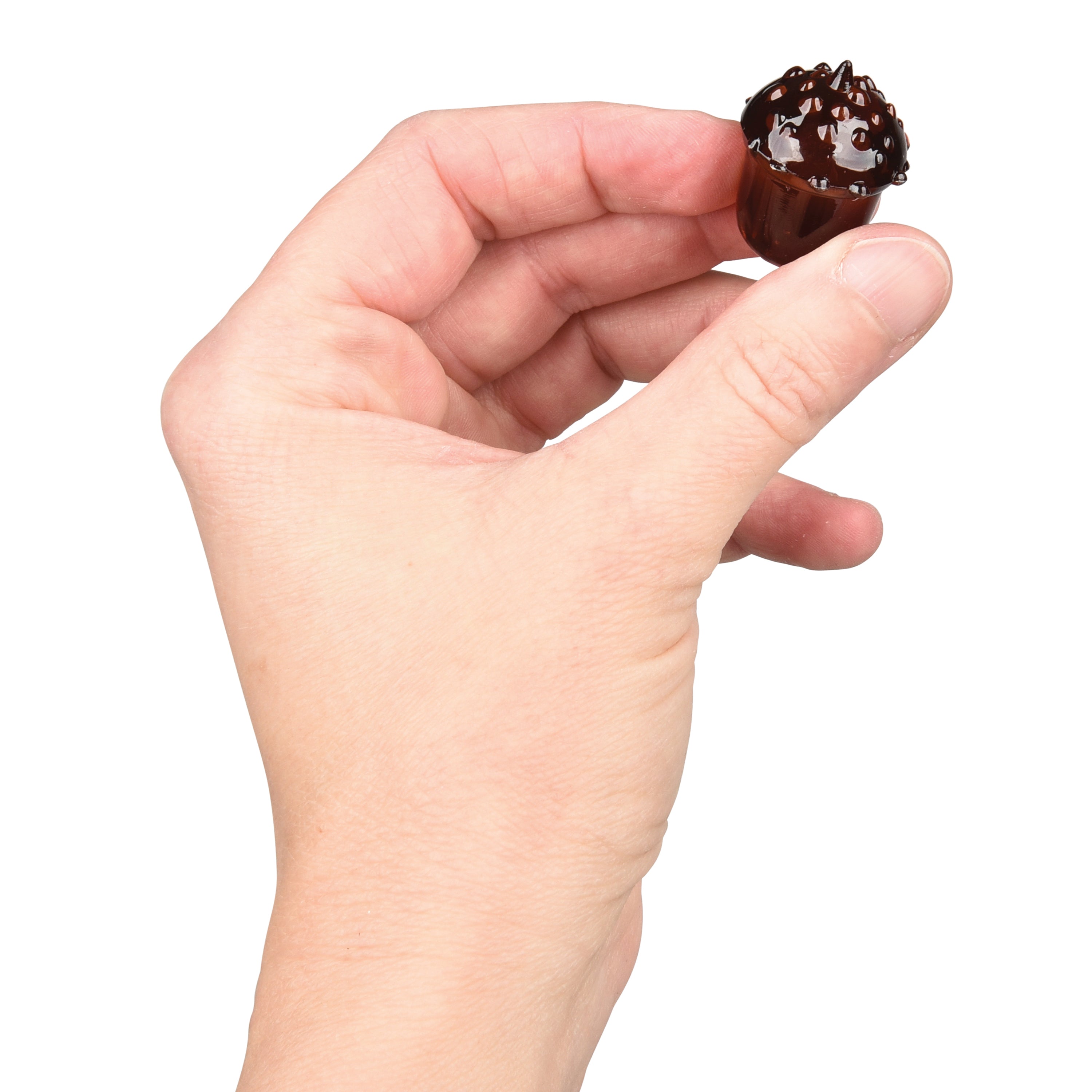 Hand holding an acorn figurine against a white background