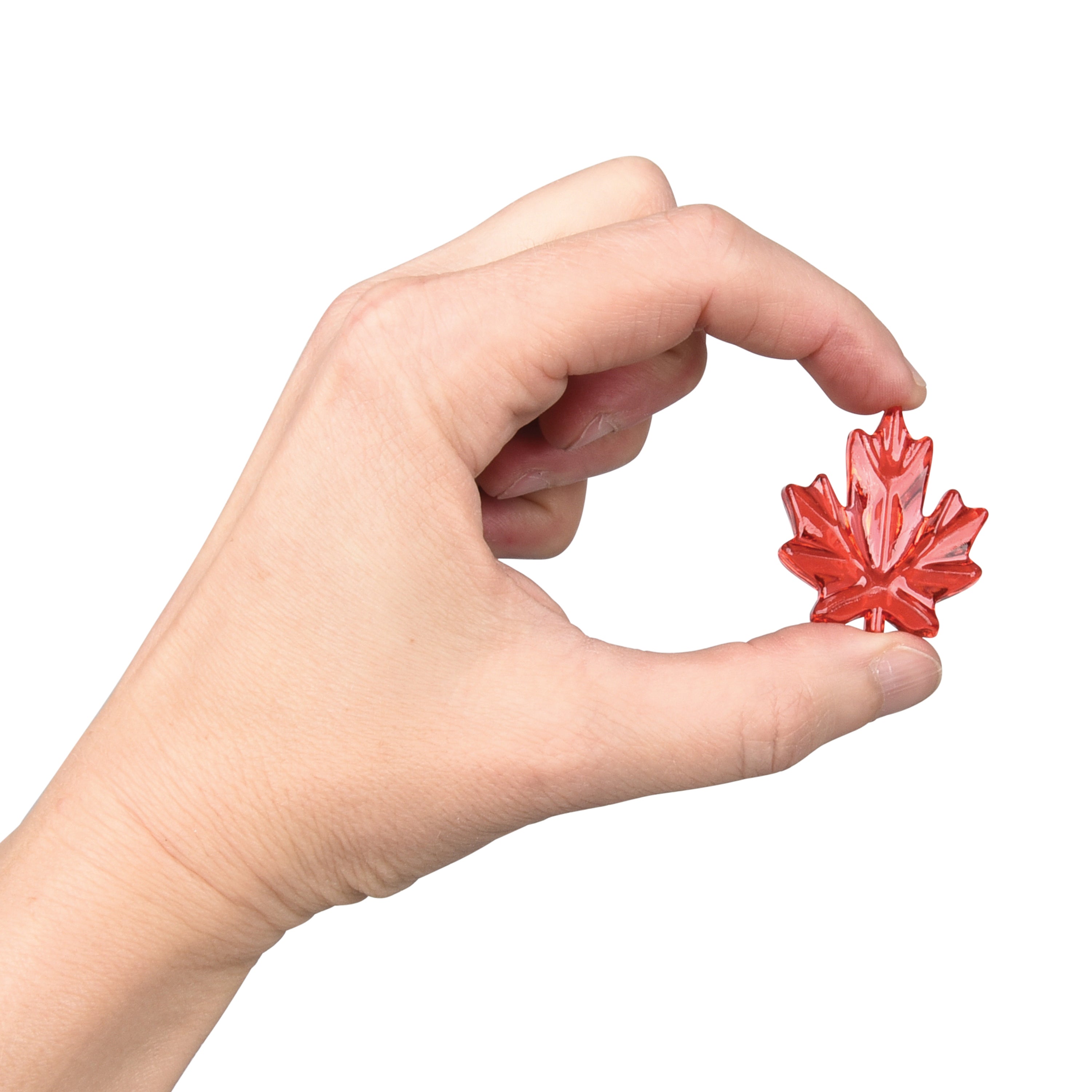 Hand holding a red maple leaf-shaped object against a white background