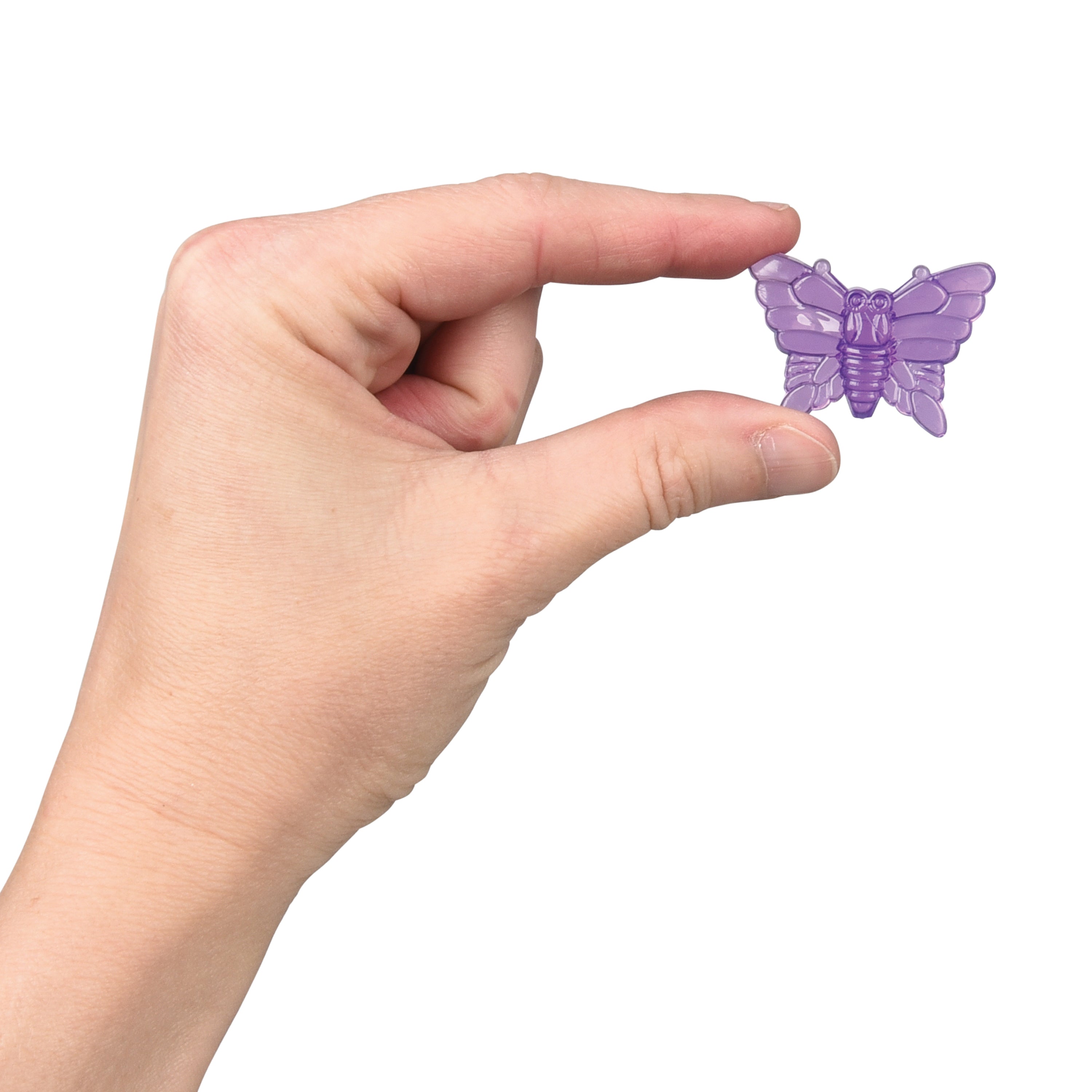 Hand holding a small purple butterfly toy against a white background