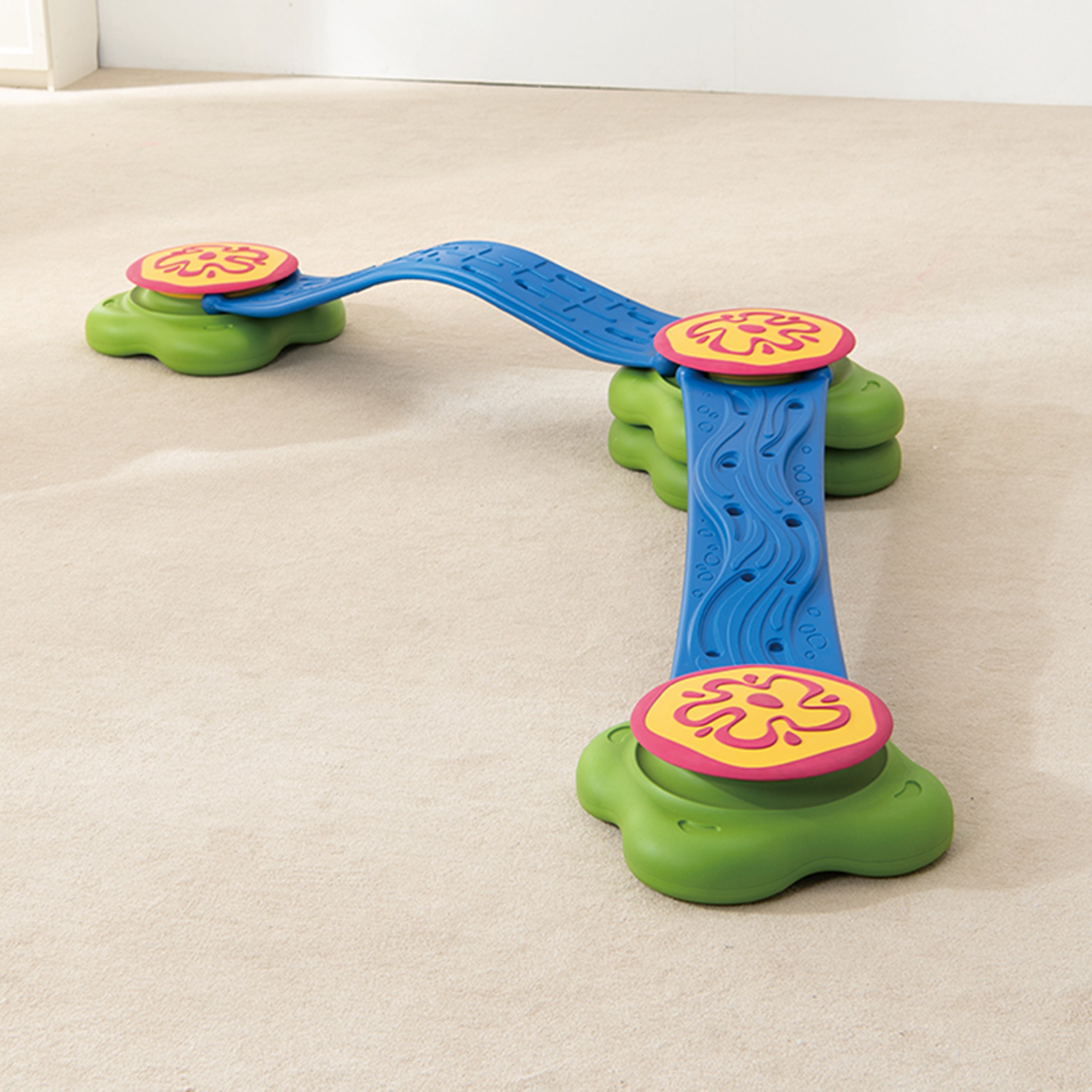 Colorful toy with a blue track and green platforms on a beige carpet