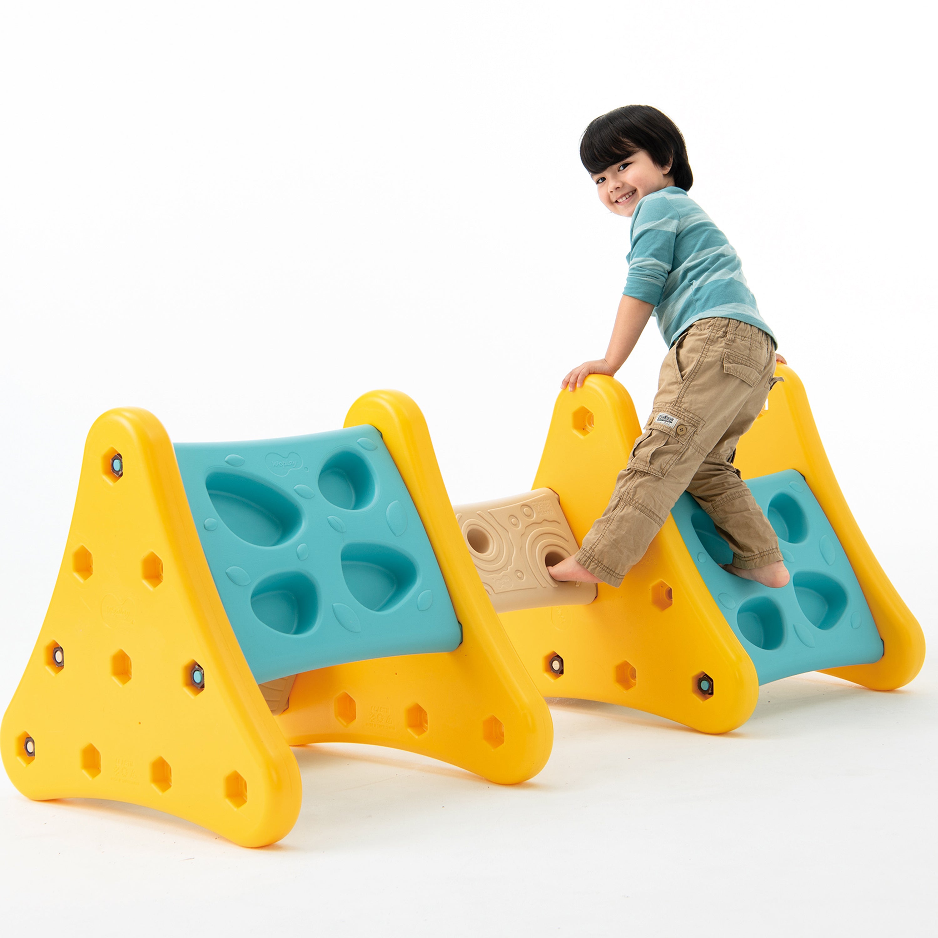 Child playing on a colorful playground structure with a white background