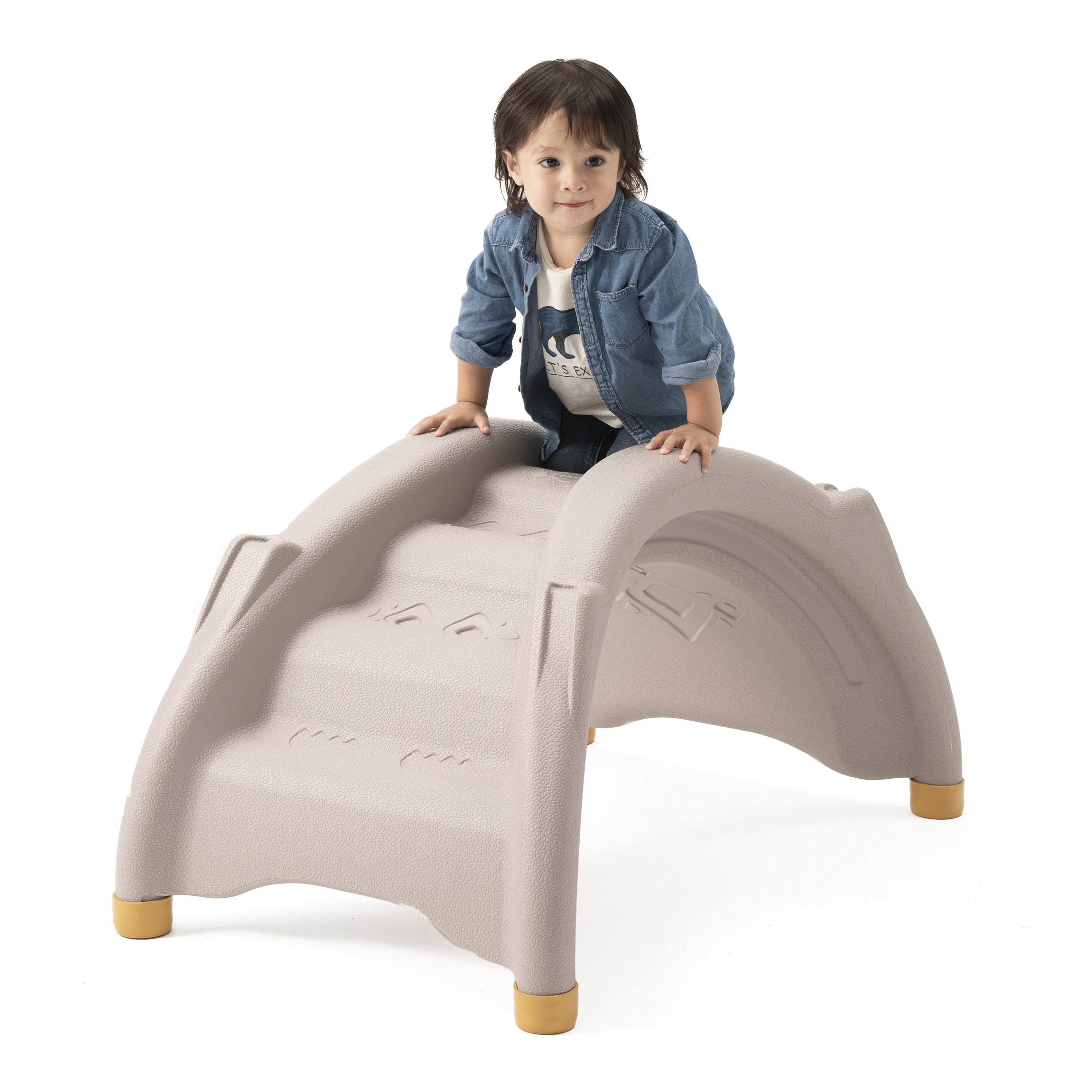 Child sitting on a beige playground structure with a white background