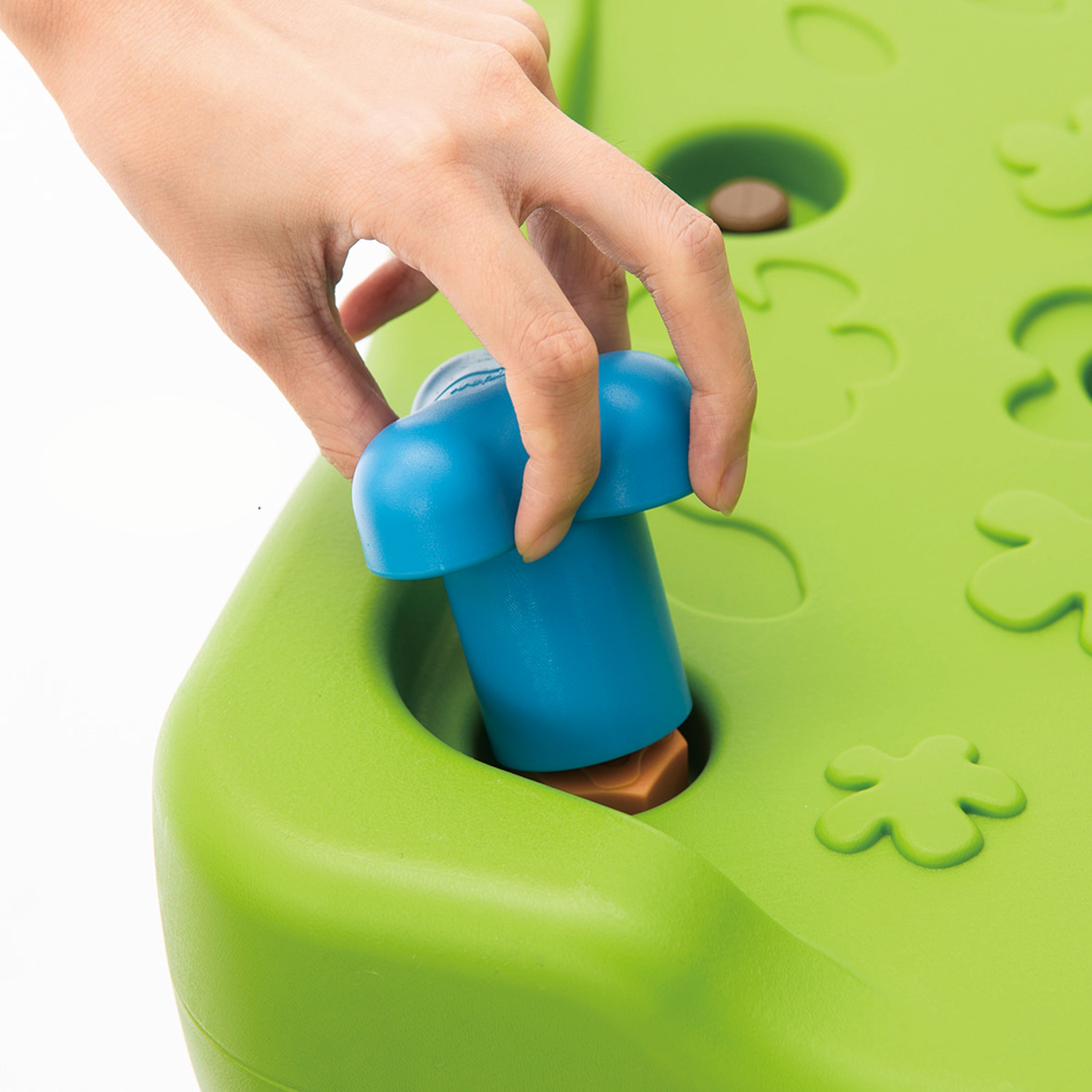 Hand interacting with a blue handle on a green puzzle toy