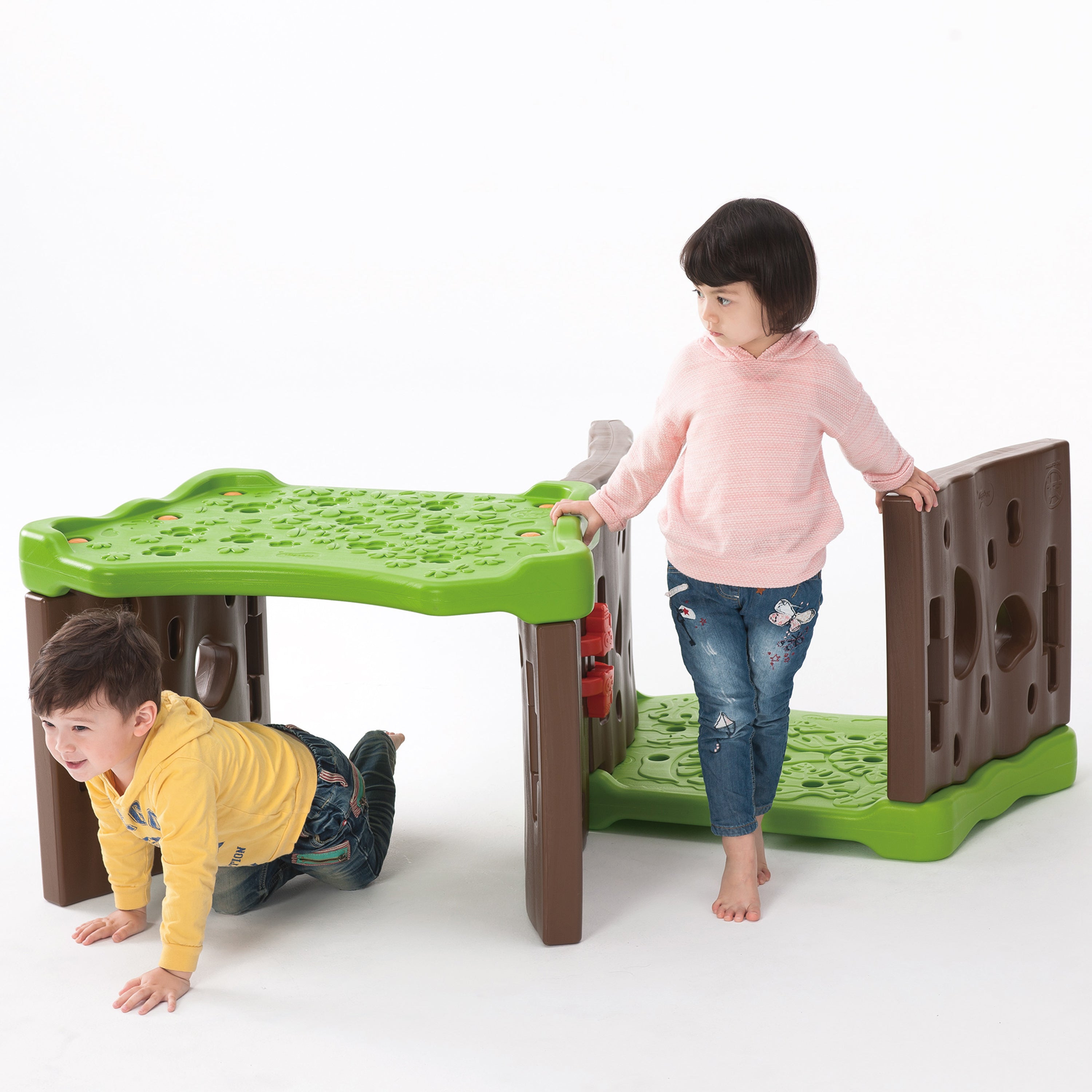 Children playing with a green and brown playset on a white background
