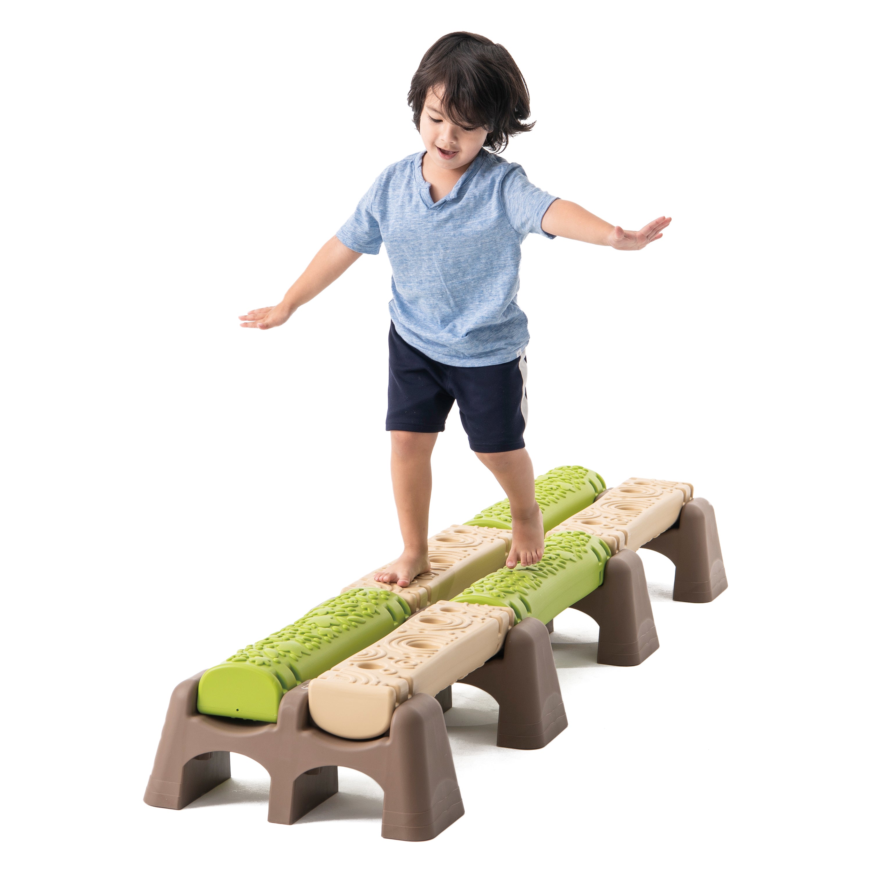 Child standing on a set of playground balance beams with a white background
