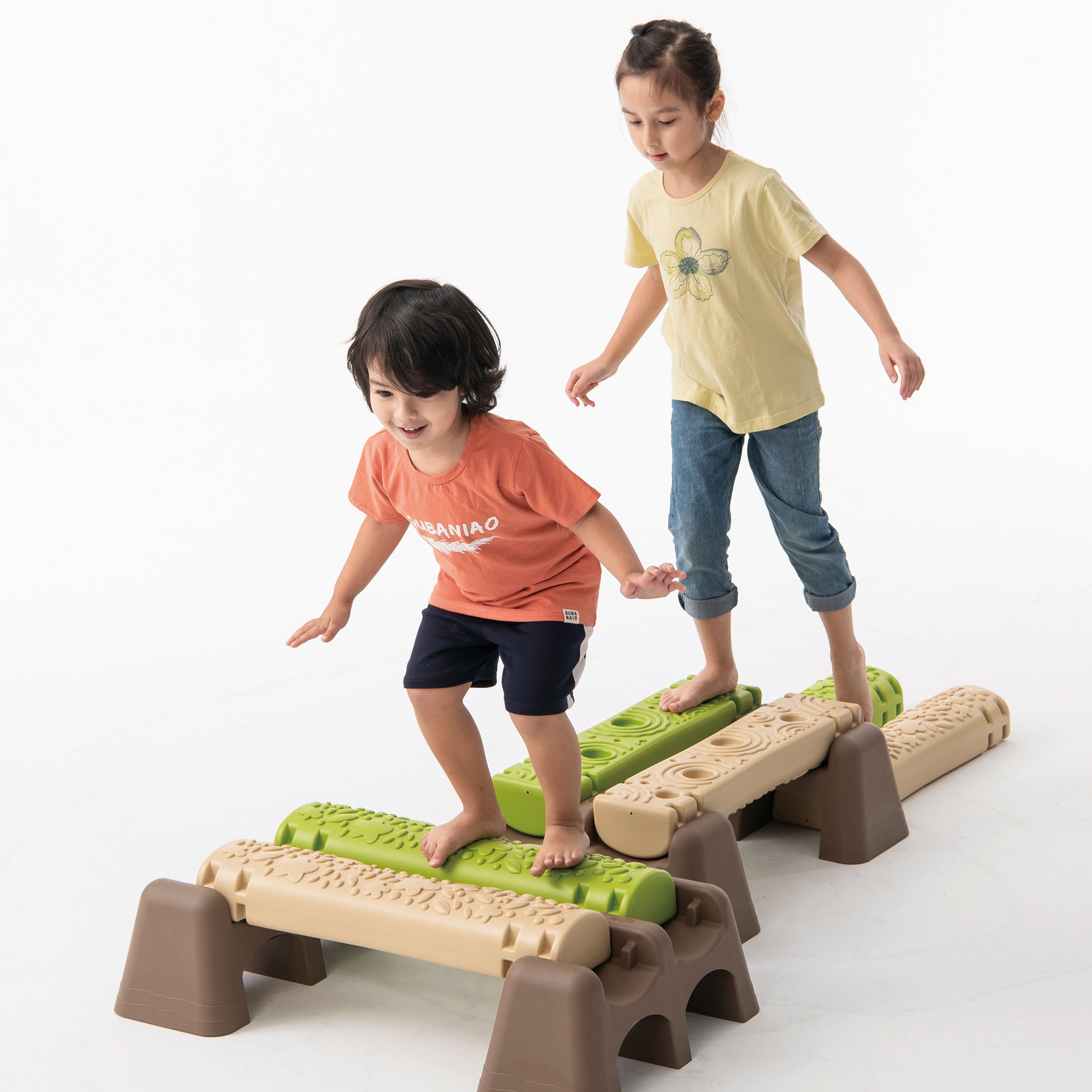 Two children playing on a set of plastic steps with green and brown colors.