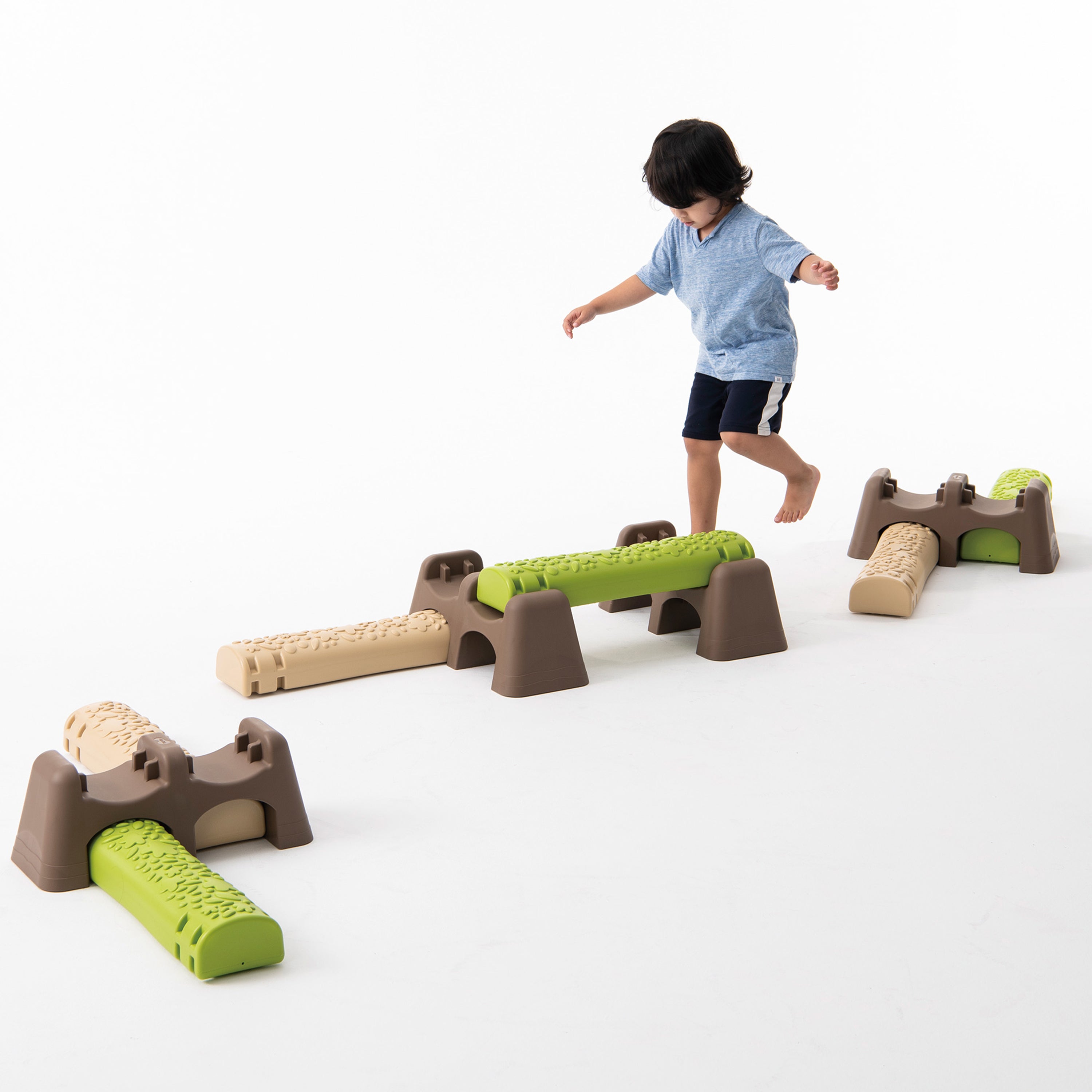 Child playing with a set of playground equipment on a white background