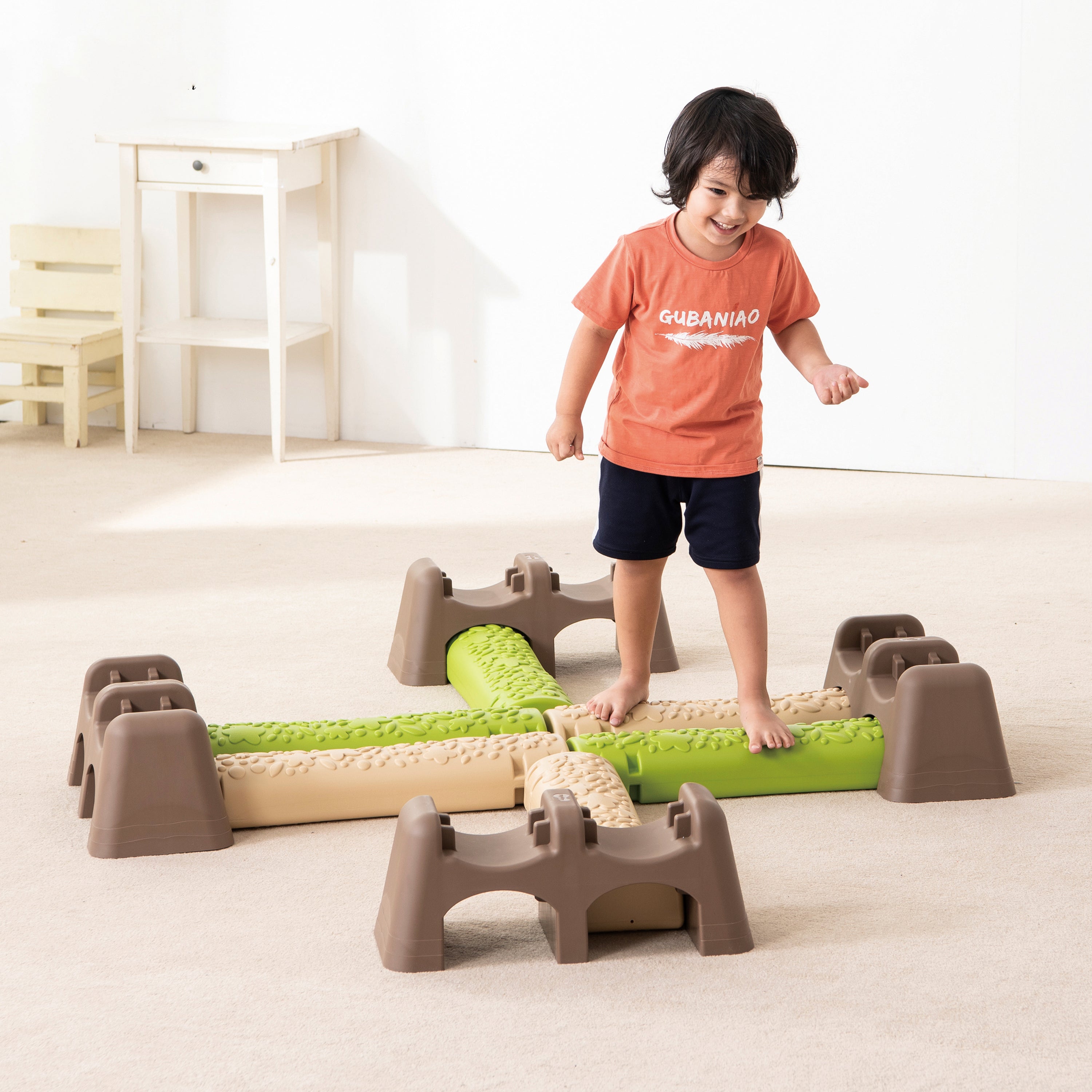 Child playing with a set of blocks on a light-colored floor.