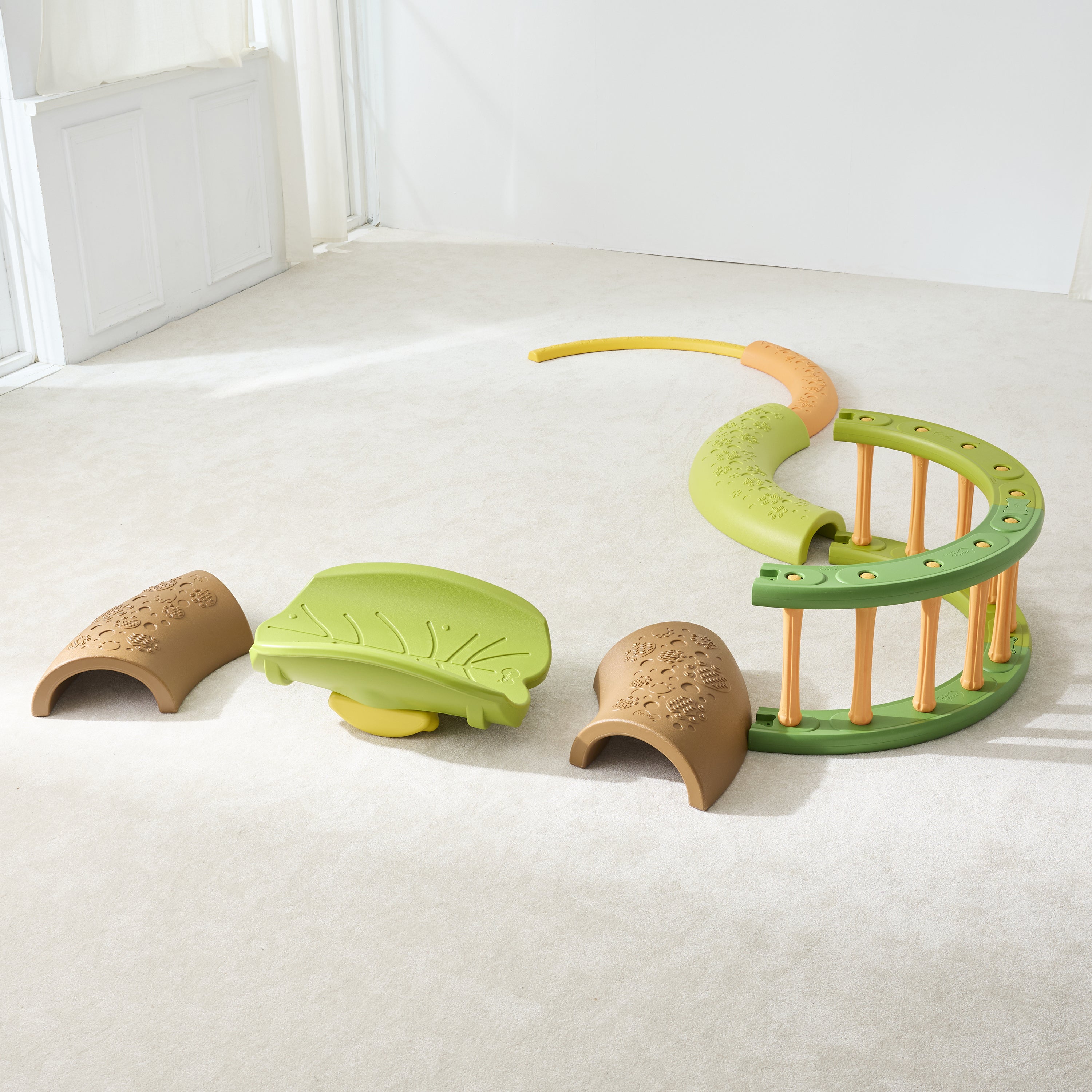 Children's toy set with green and brown pieces on a light-colored floor.