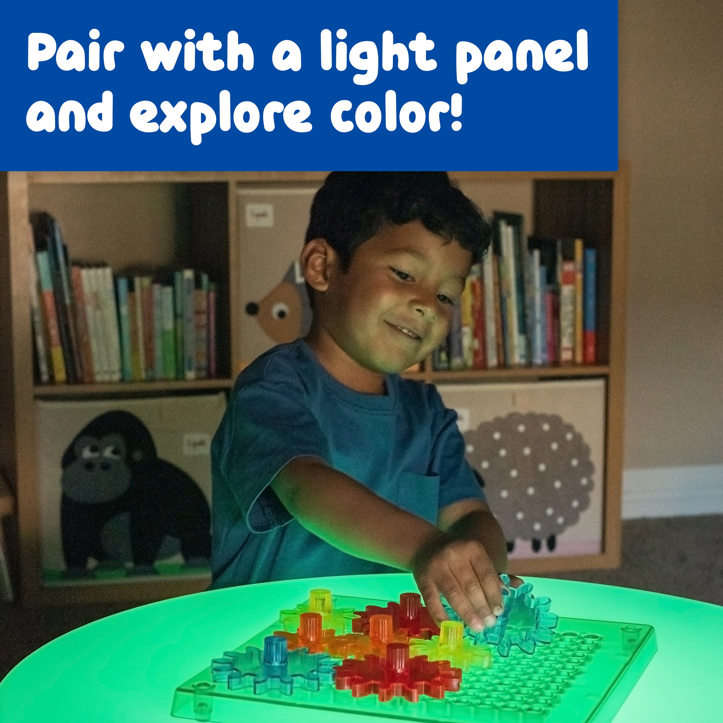 Child playing with a colorful building set on a light-up table in a room with bookshelves.