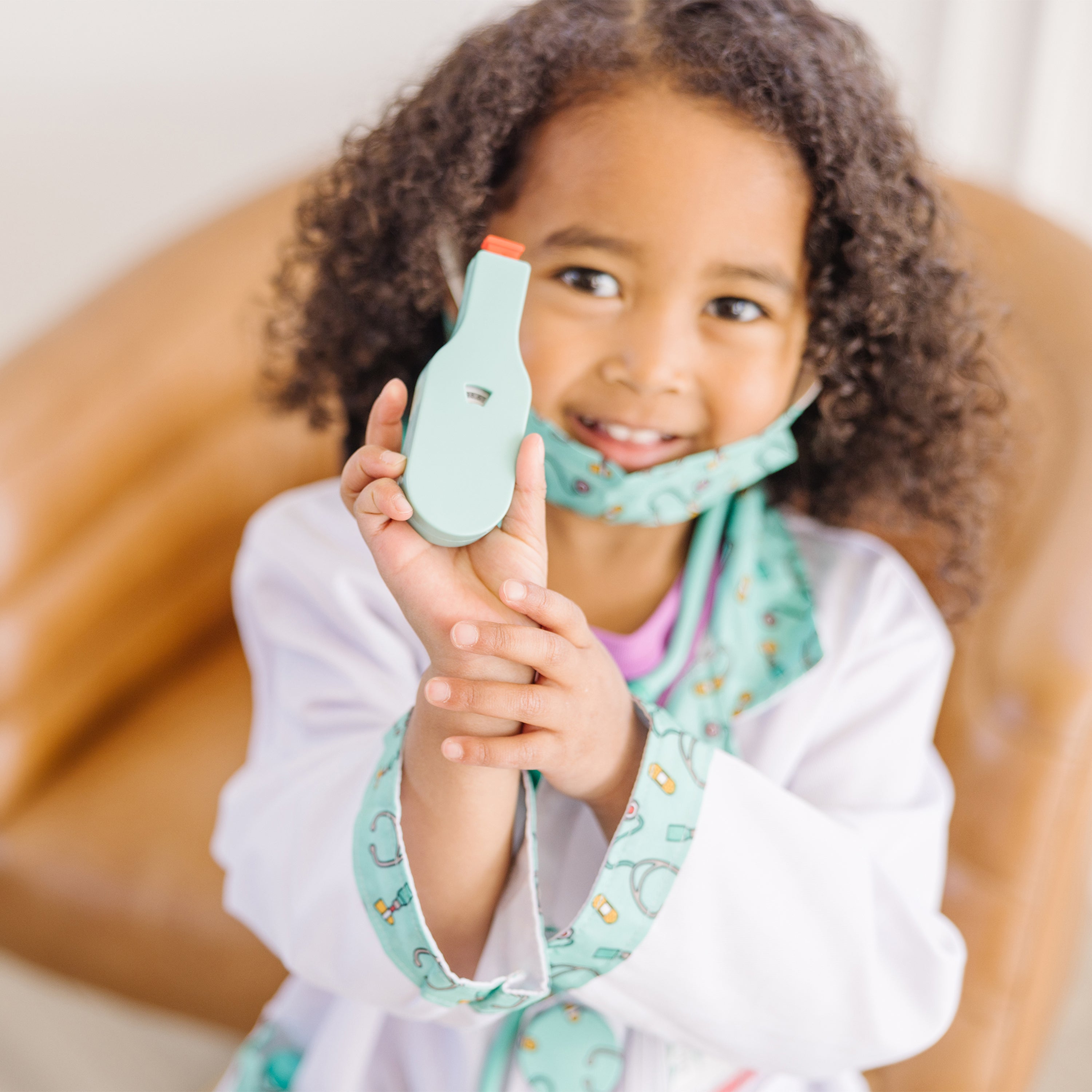 Child playing doctor with toy stethoscope and syringe