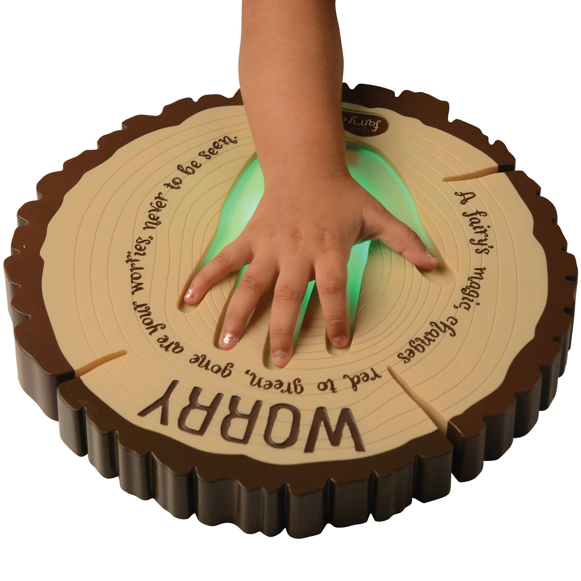 Wooden disc with engraved text and a child's hand pressing down on it