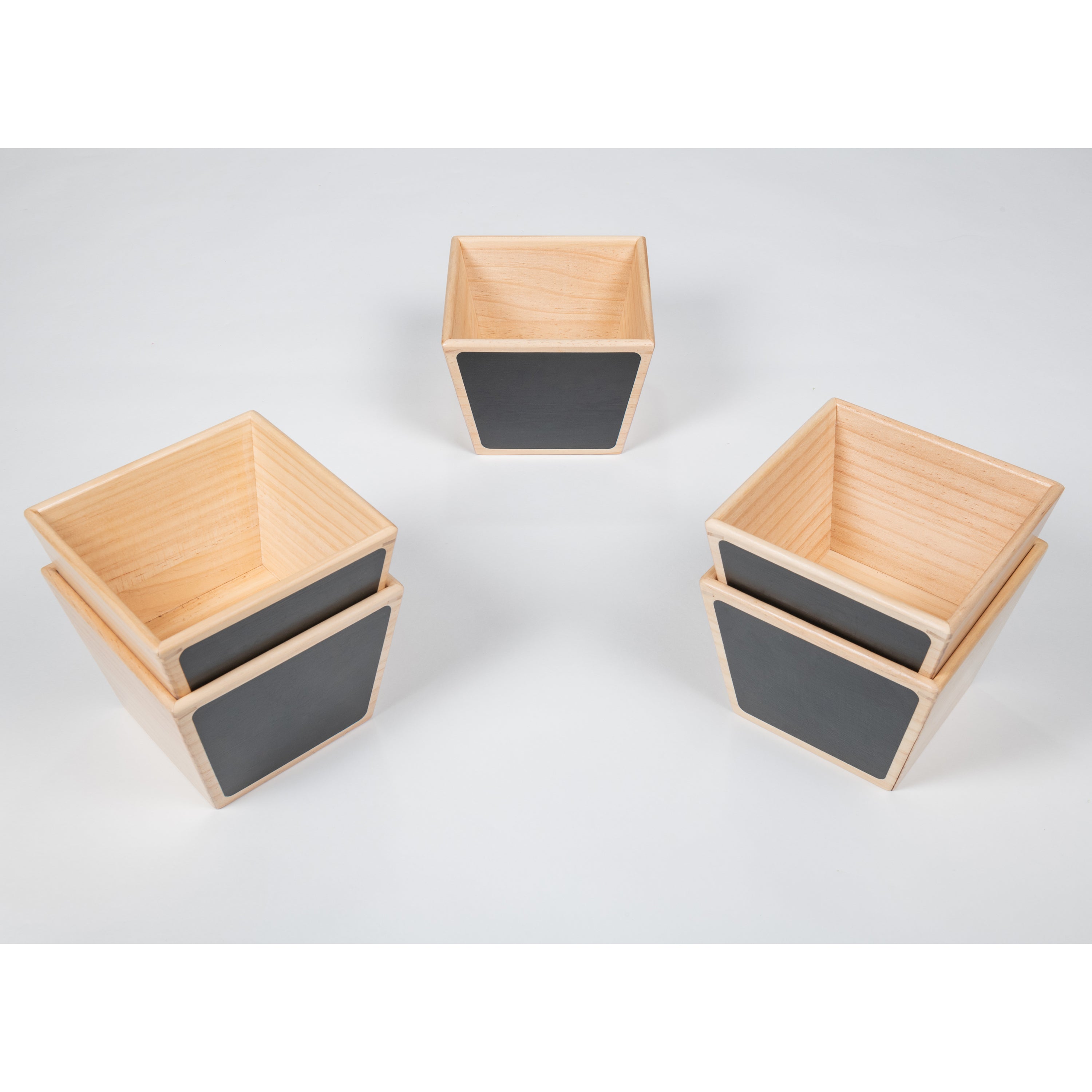 Three square wooden containers with gray interior on a white background