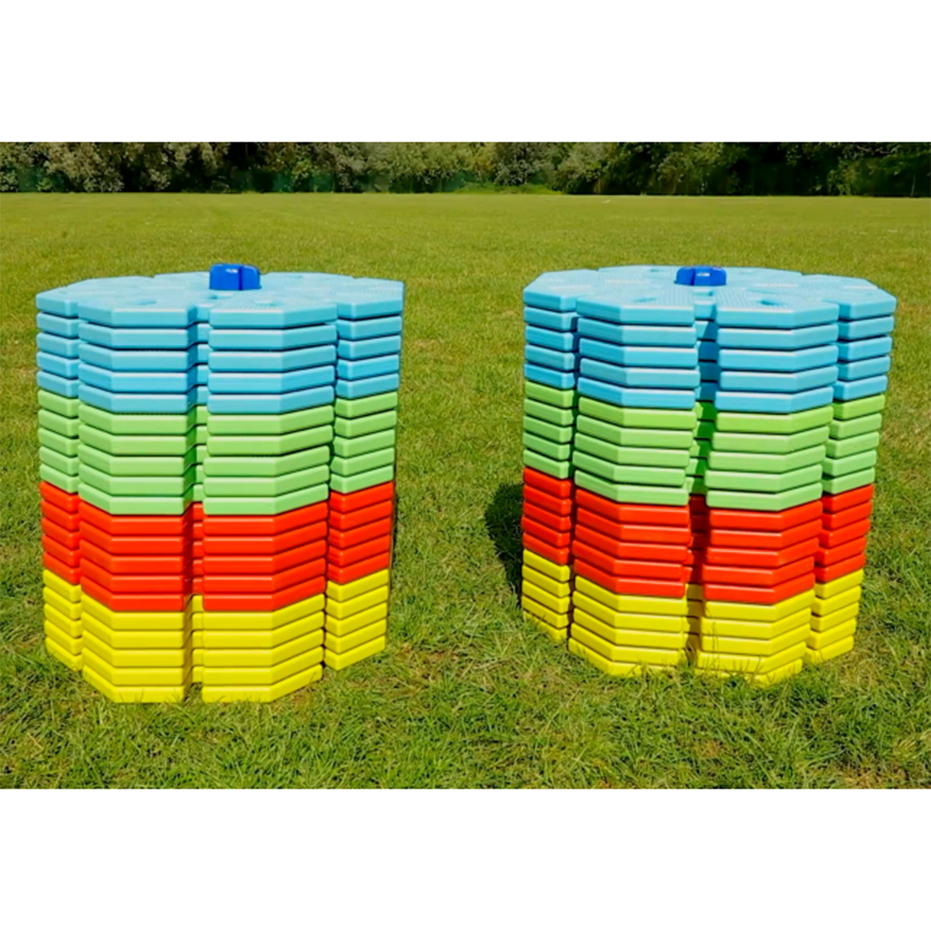 Stacks of colorful plastic building pieces on a grassy field
