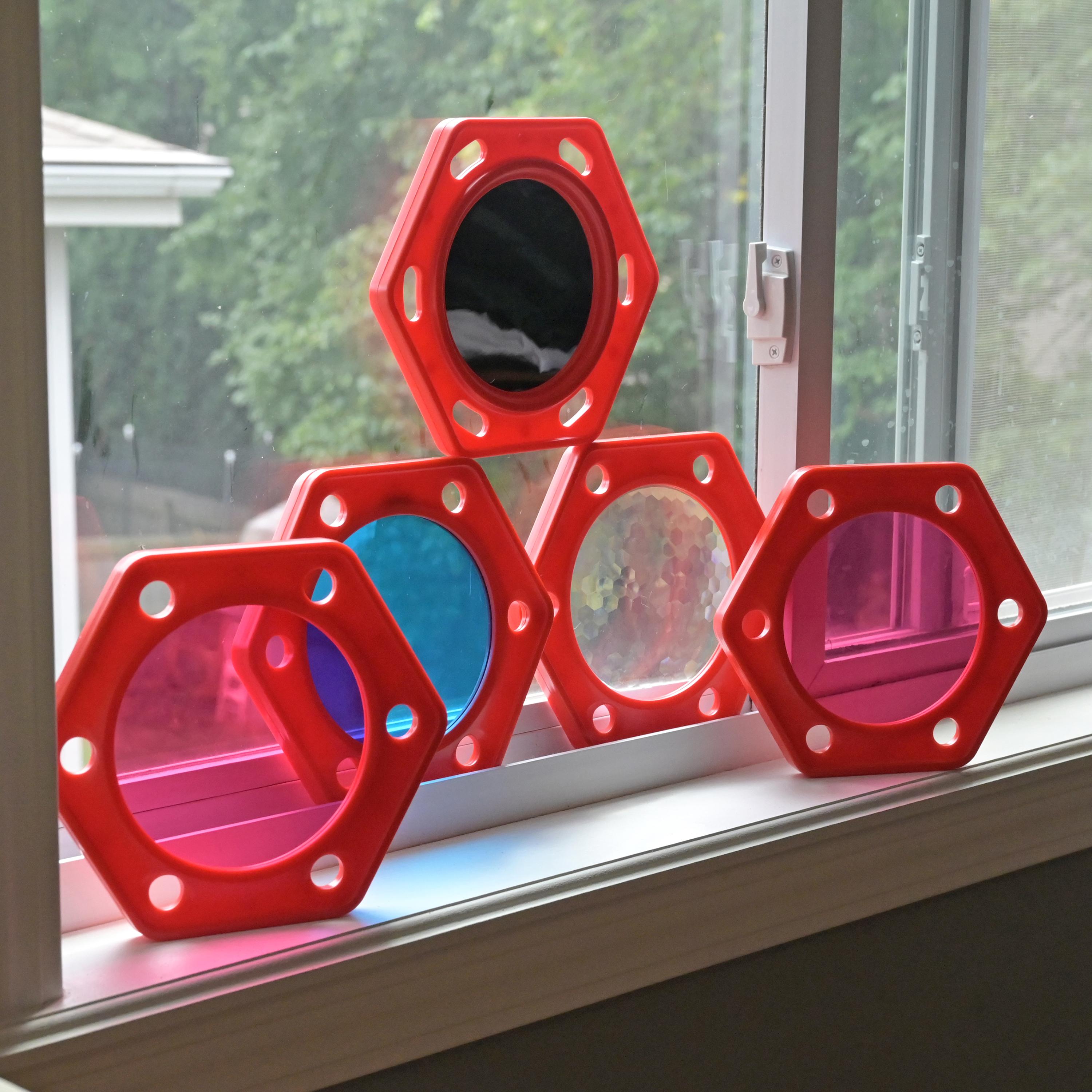 Red geometric objects with colorful centers on a windowsill