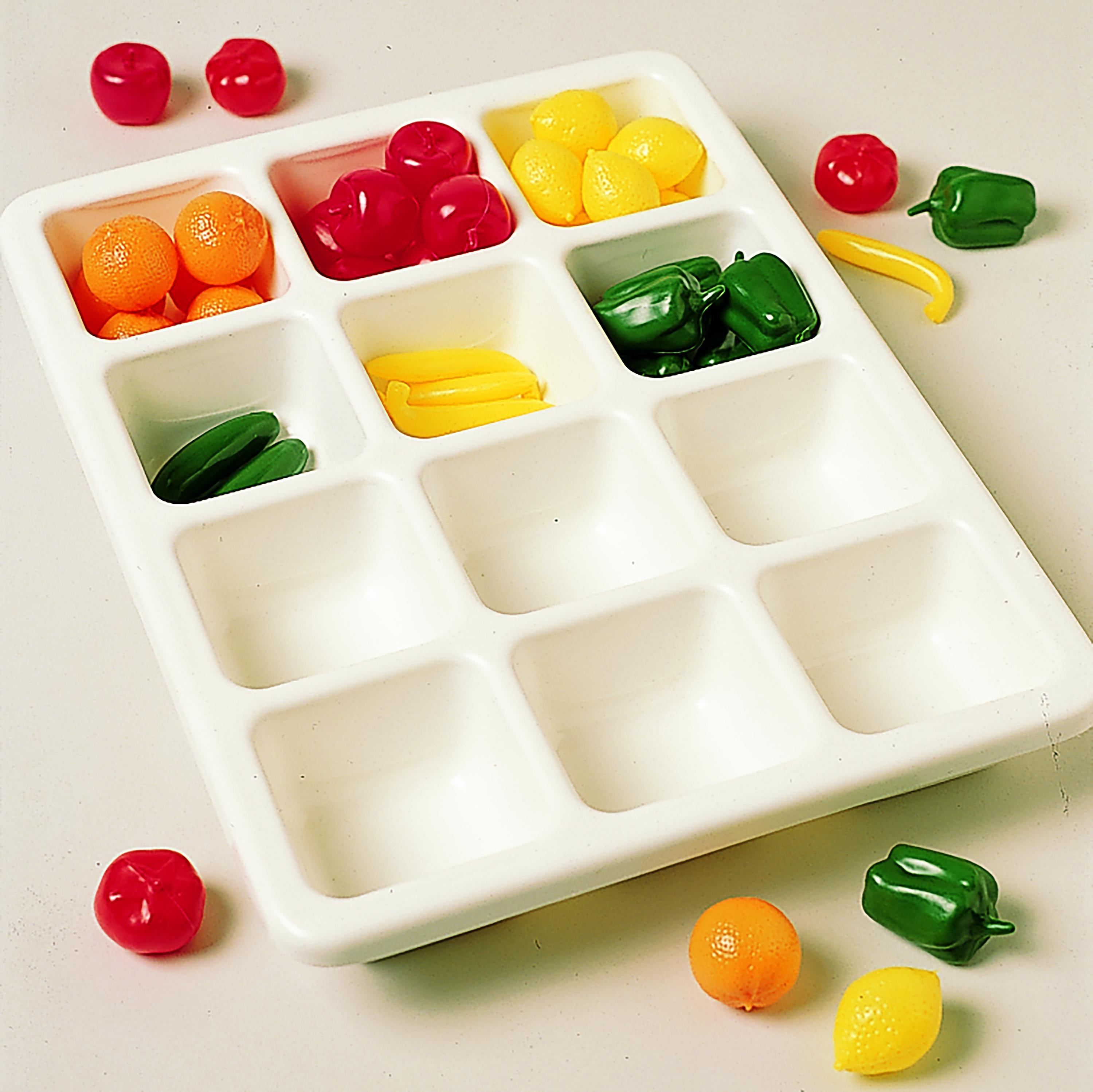 White tray with compartments filled with colorful figures on a light background.