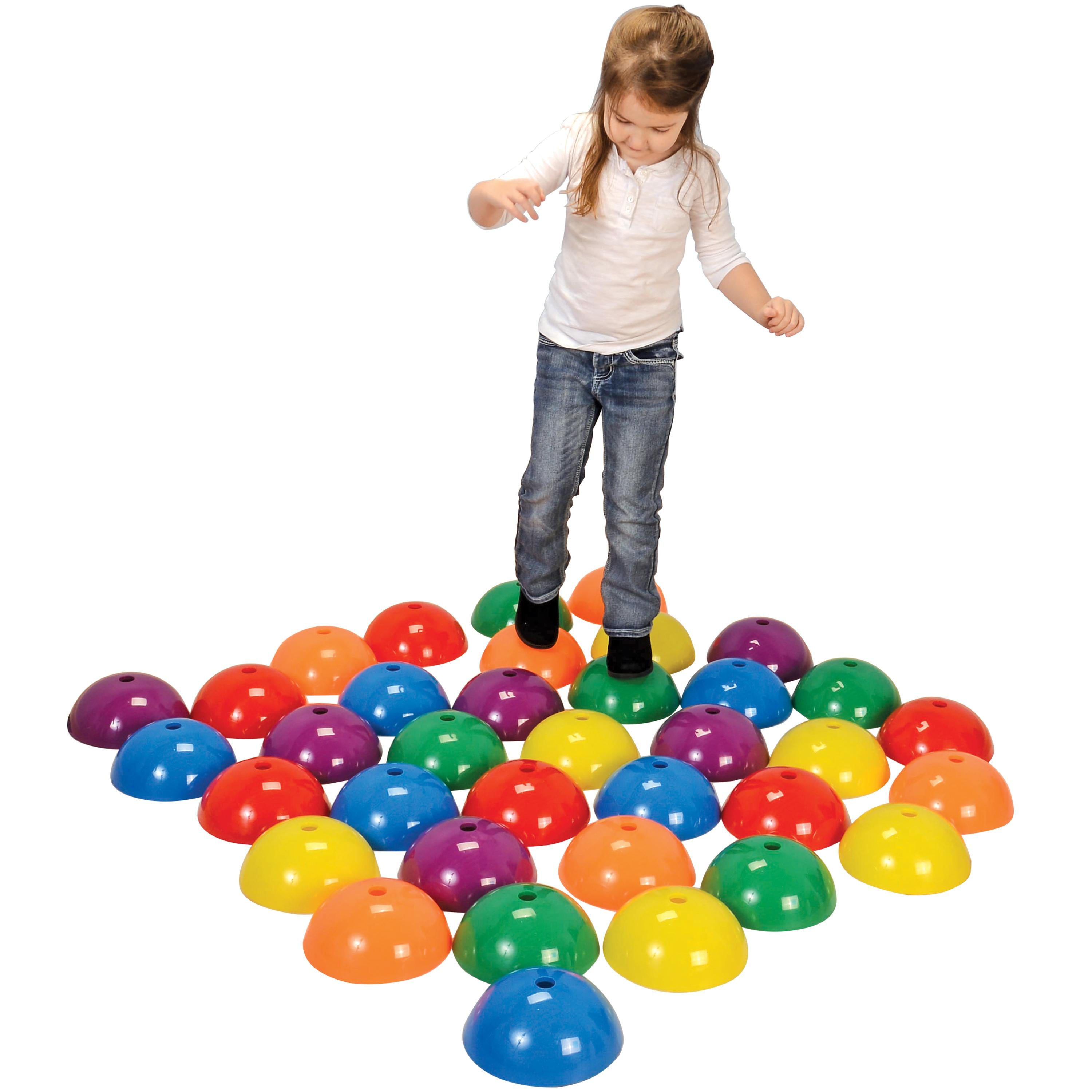 Child playing with colorful plastic cones on a white background