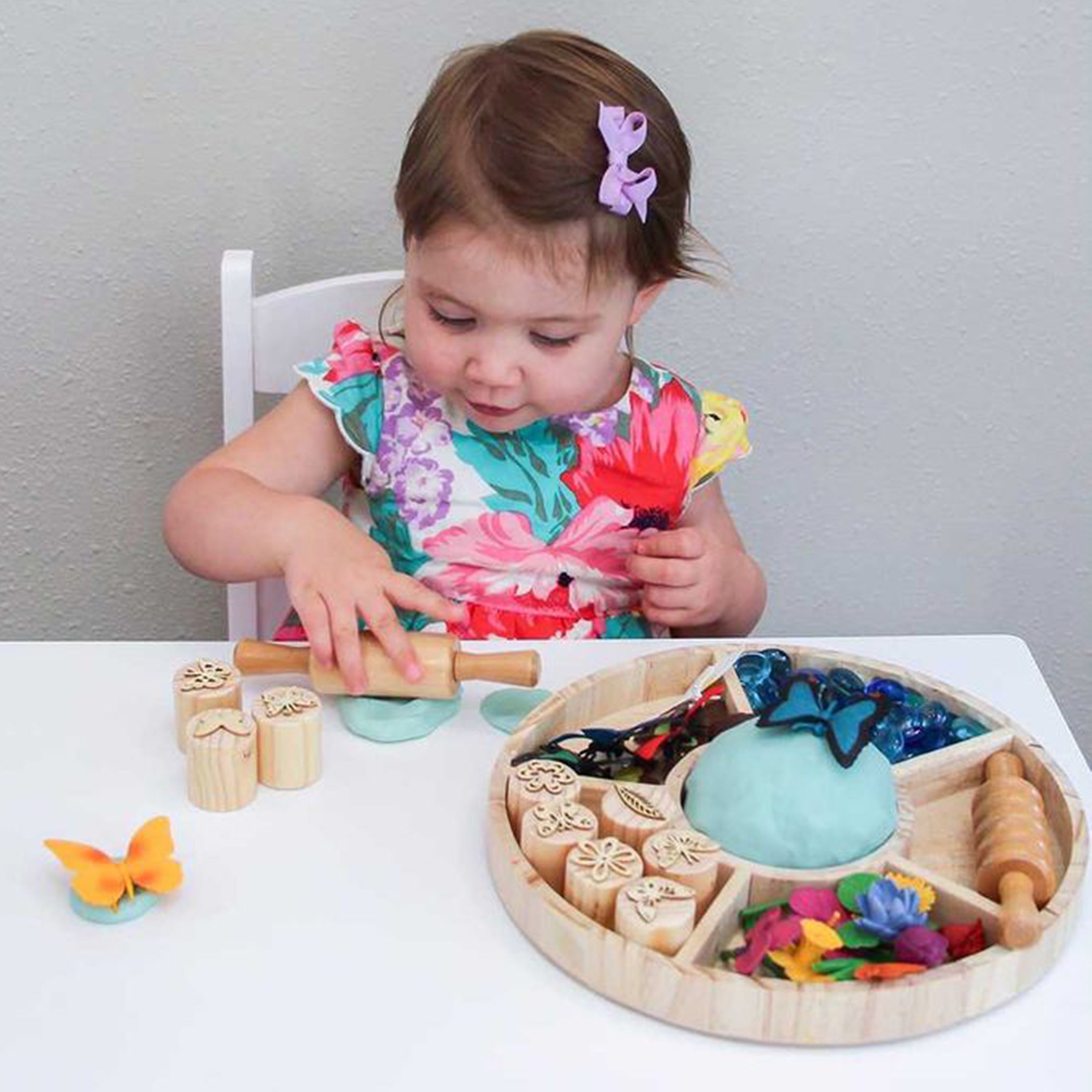 Child playing with a wooden toy set on a table