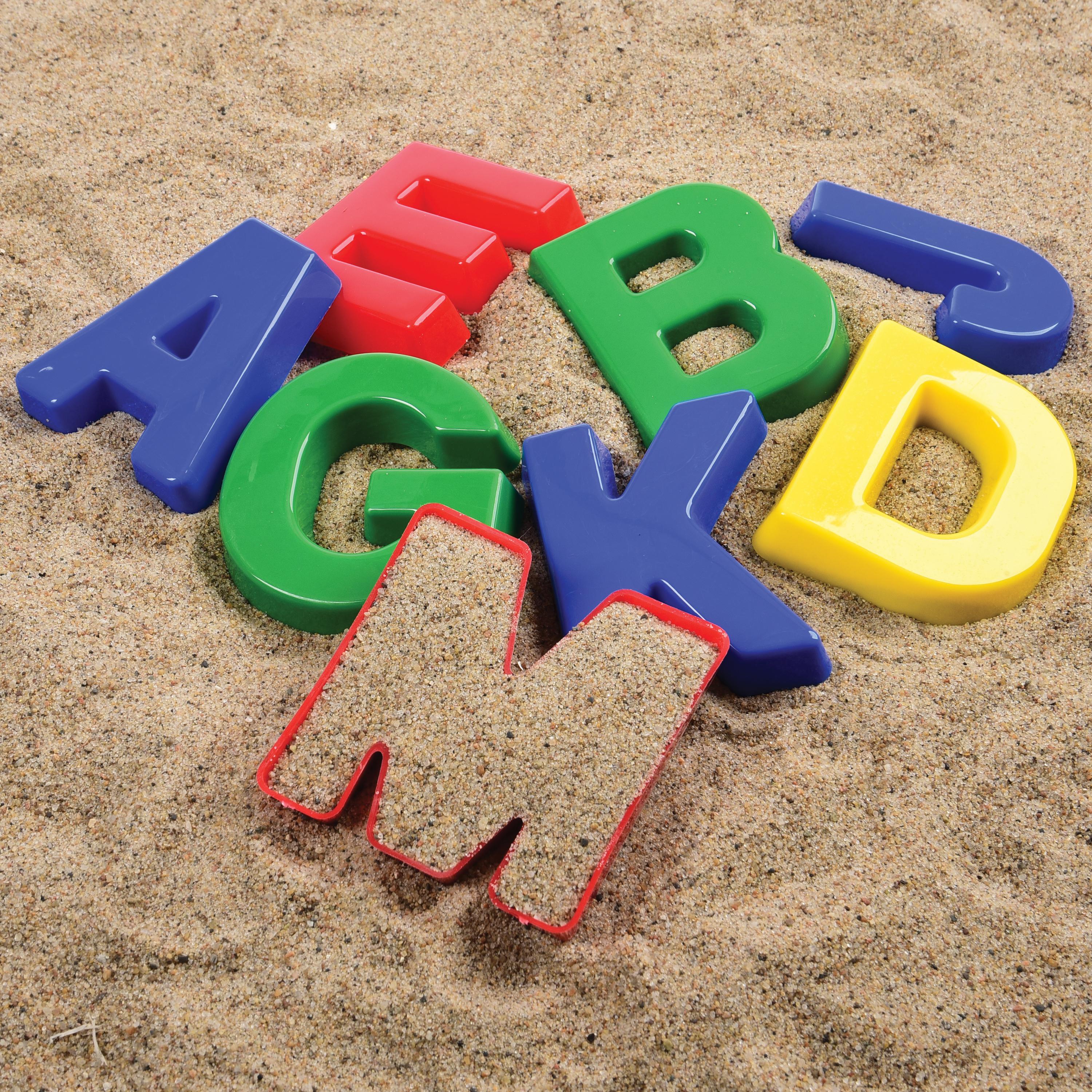 Colorful plastic letters on sand