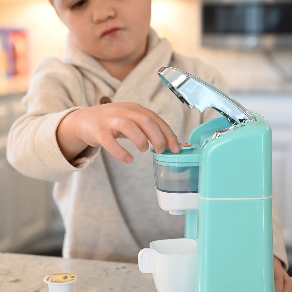 Kid Using Pod In Realistic Toy Coffee Maker