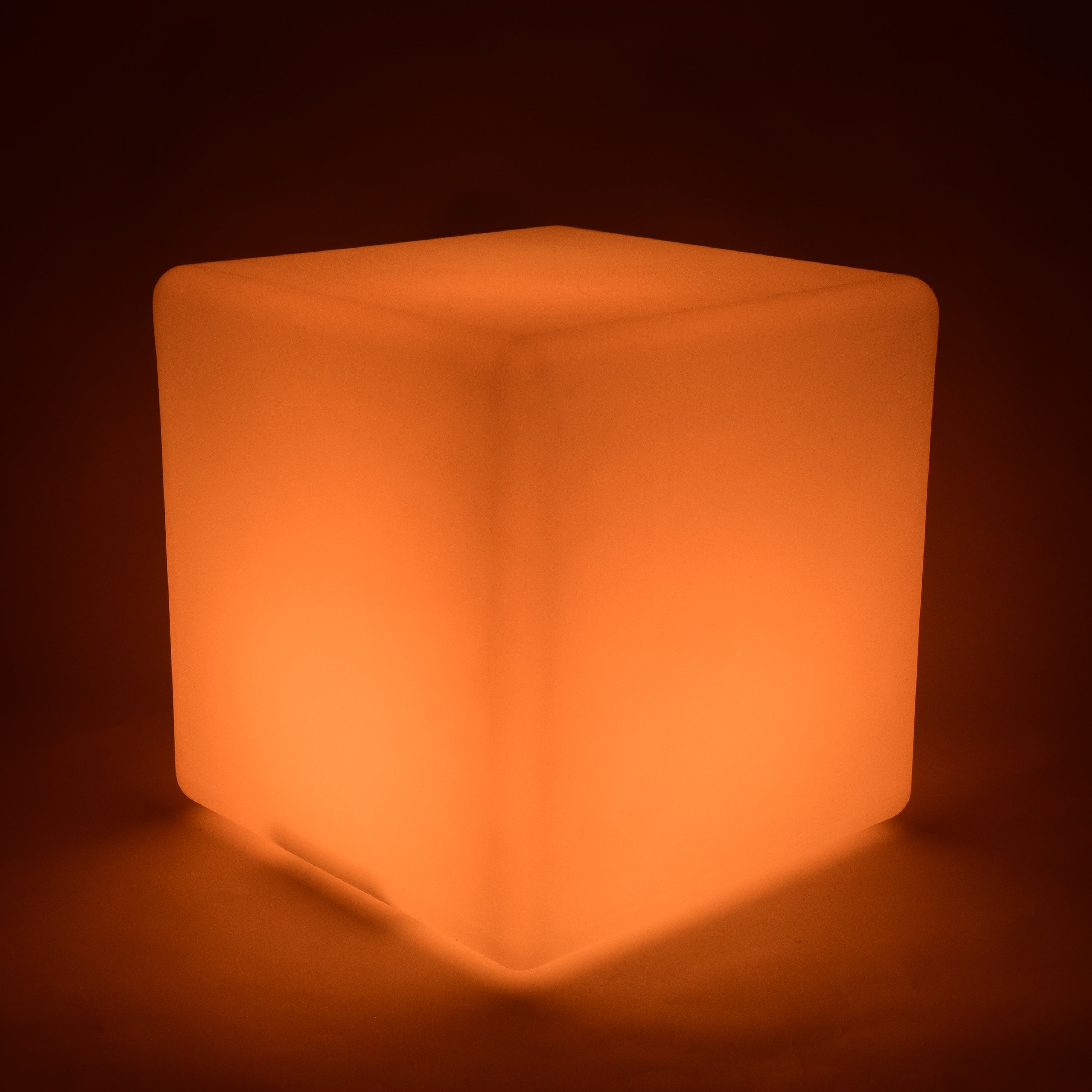 Cube-shaped illuminated object with a warm orange glow on a dark background
