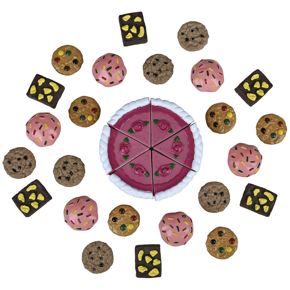 Toy cake with various toy cookies around it on a white background