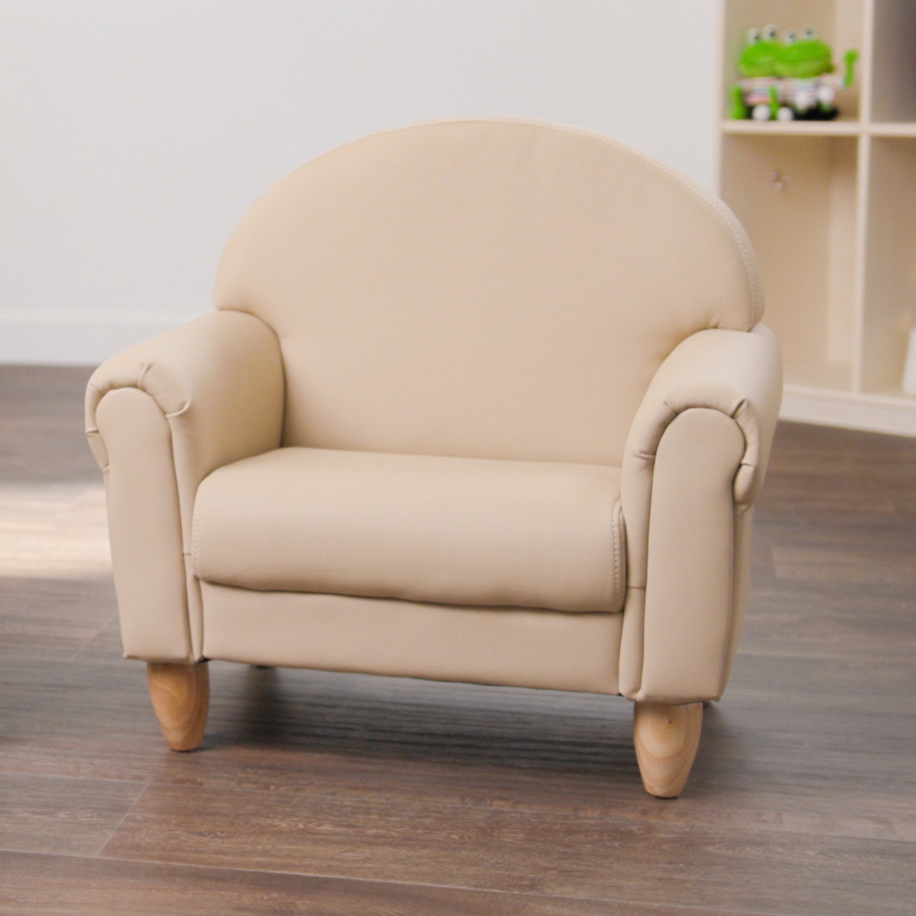 Beige armchair on a wooden floor with a blurred background
