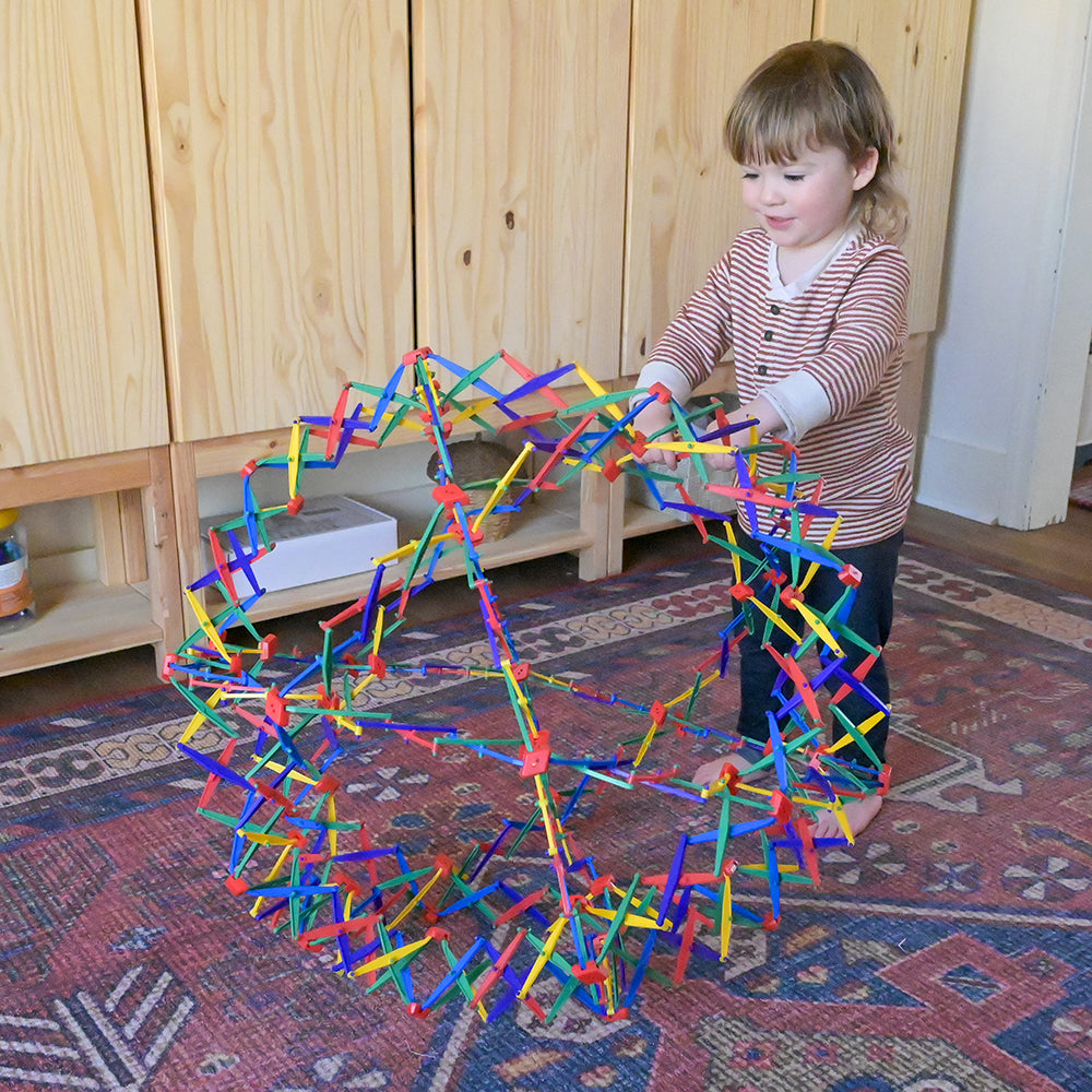 Toddler Playing with Rainbow Hoberman Sphere