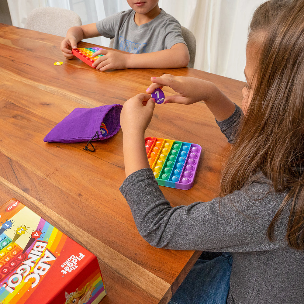 Two Kids Playing ABC Pop & Match Bingo At Home